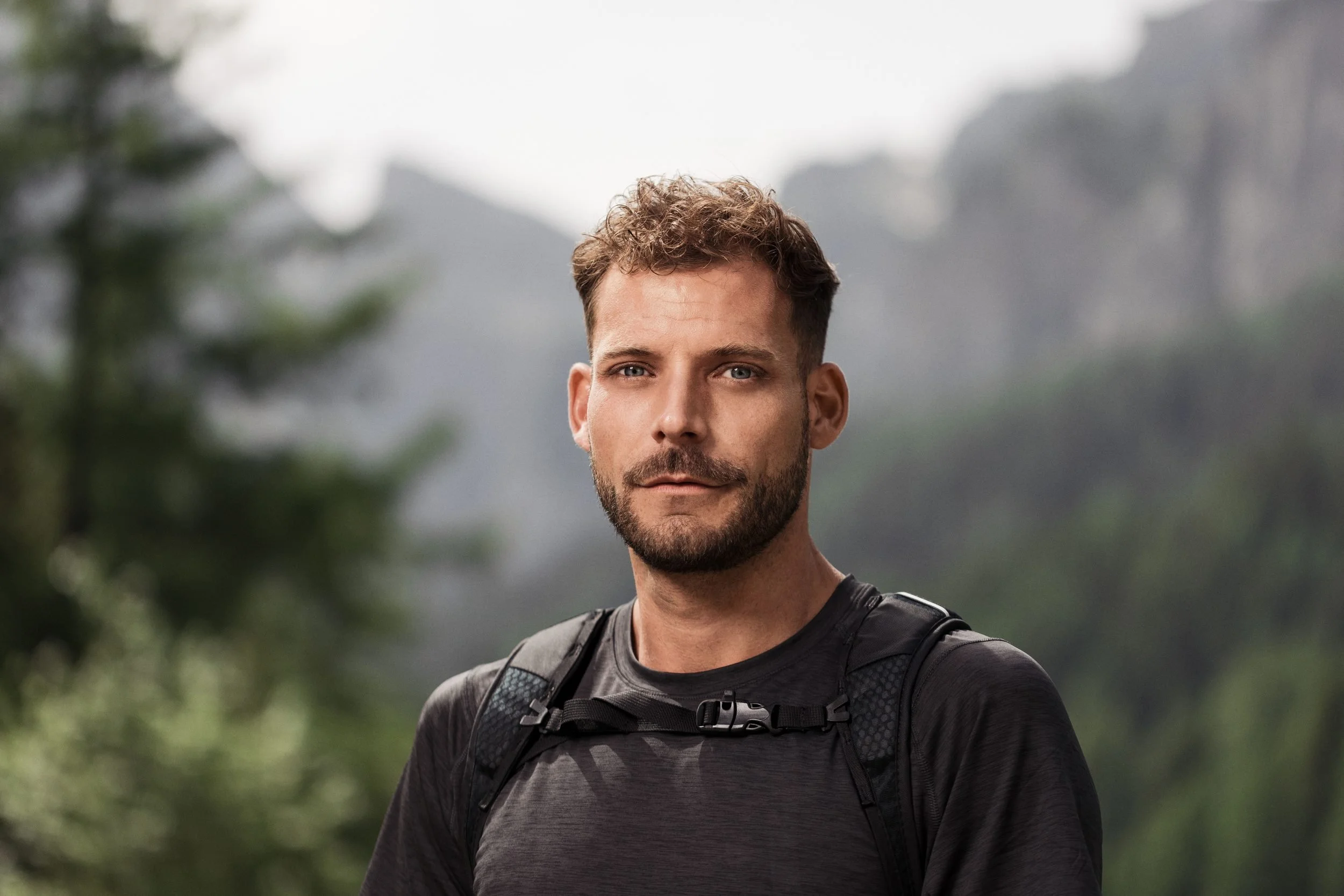 Wanderer mit Rucksack vor Waldkulisse