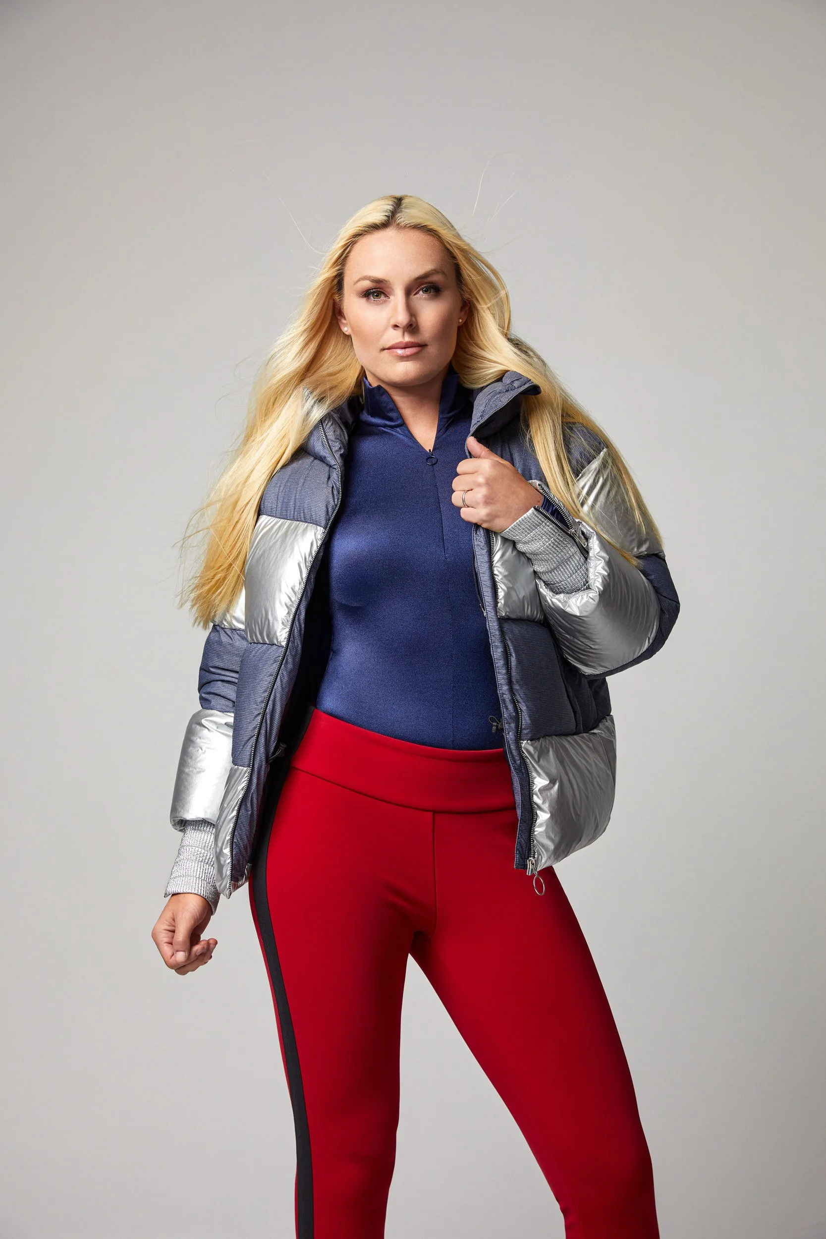 Lindsey Vonn in silber-blauer Daunenjacke mit roter Leggings