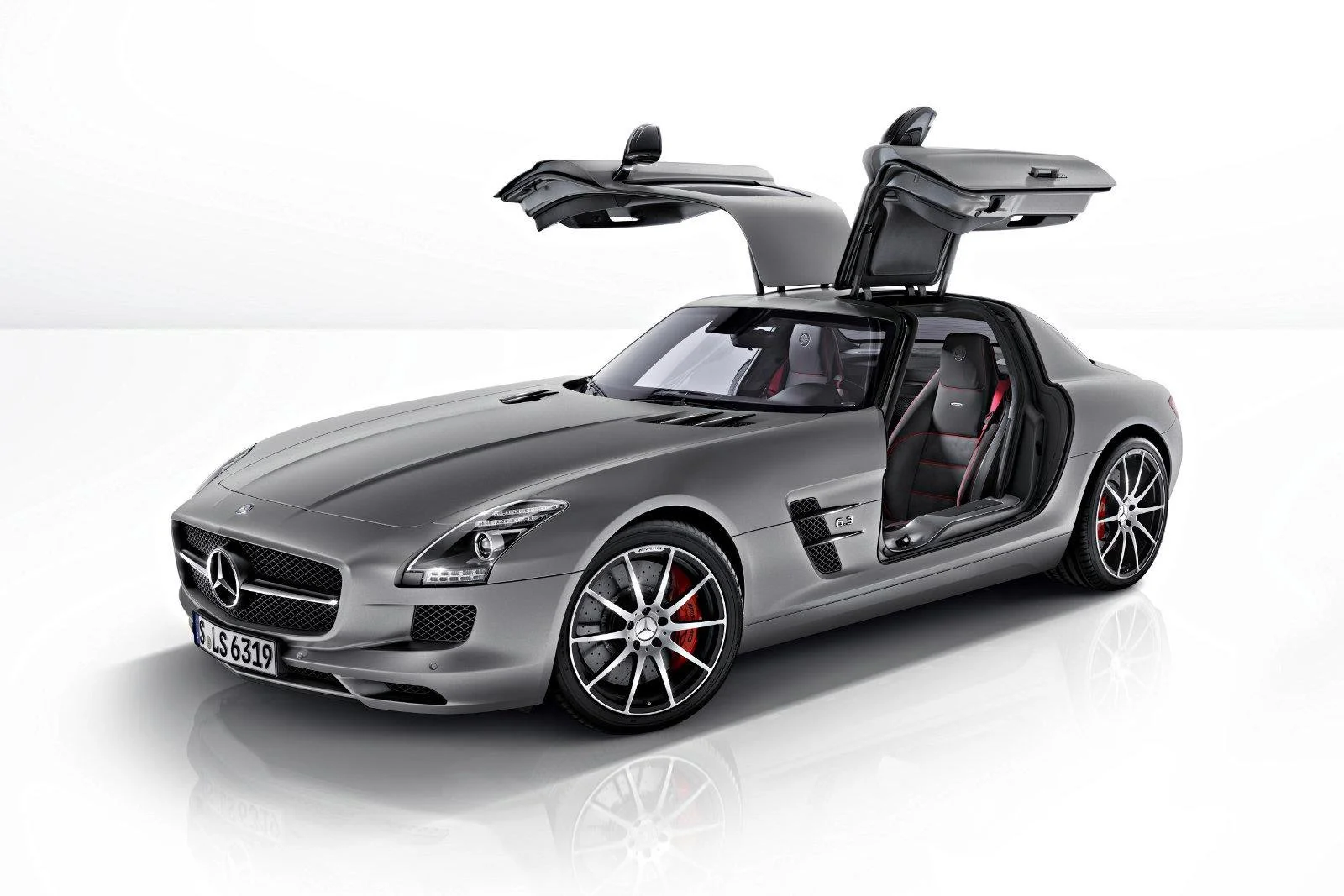 Silberner Mercedes SLS AMG mit geöffneten Flügeltüren im weißen Studio – High-End-Retusche von Bildergut.