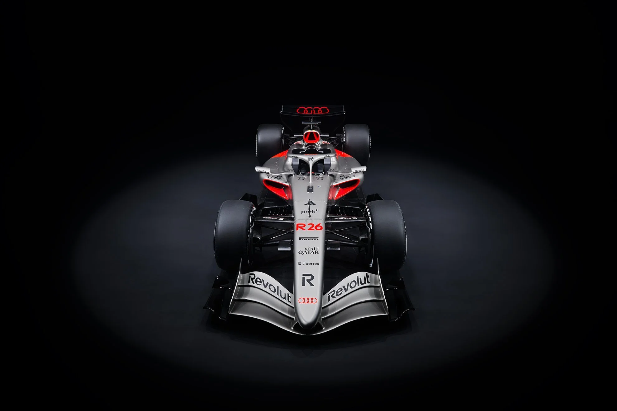 Silber-roter Audi Revolut R26 Formel-1-Bolide frontal im Spotlight vor schwarzem Hintergrund – Retusche Bildergut.