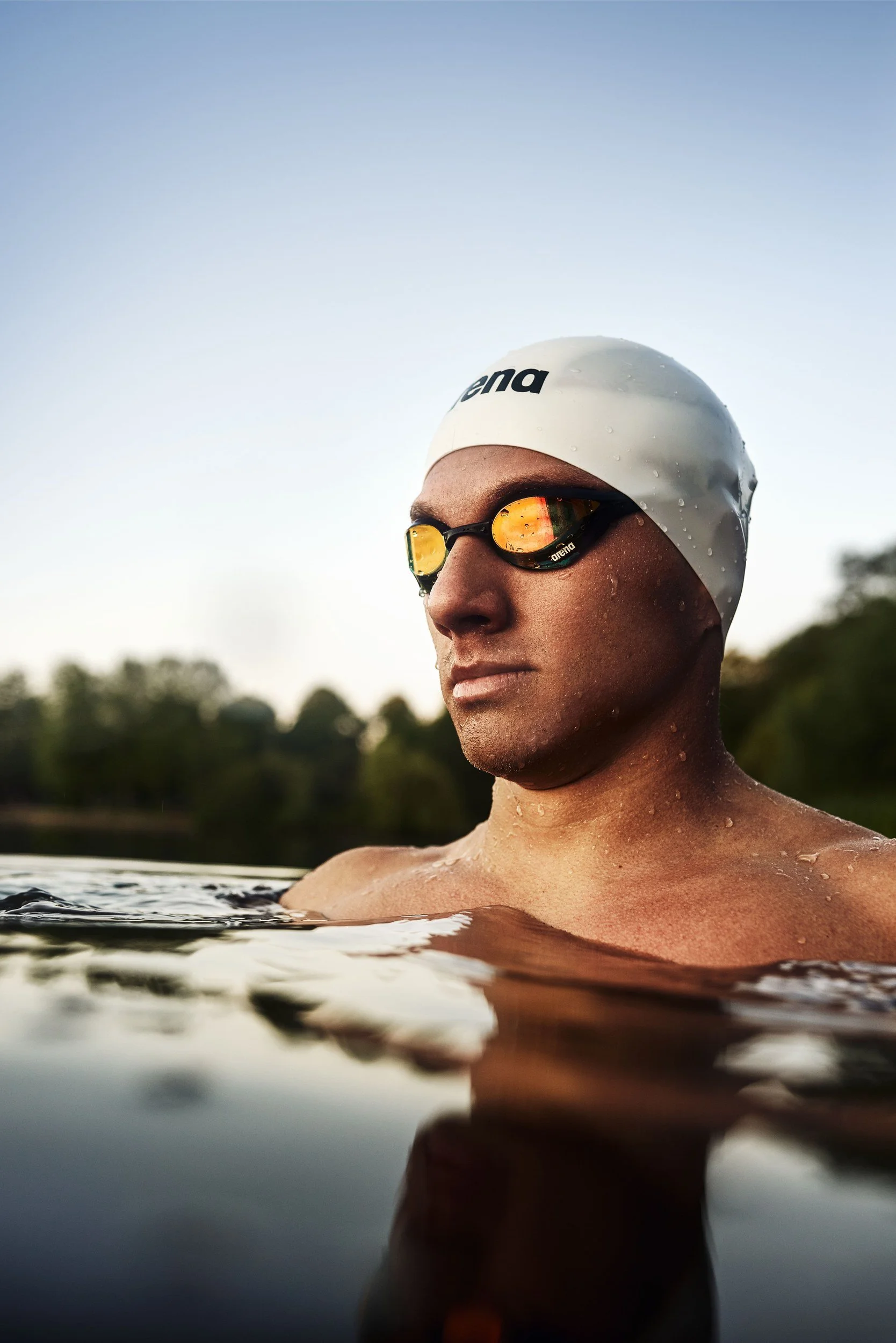 Schwimmer-Editorial von Tim Wendrich: frontales Porträt mit verspiegelter Schwimmbrille im goldenen Licht