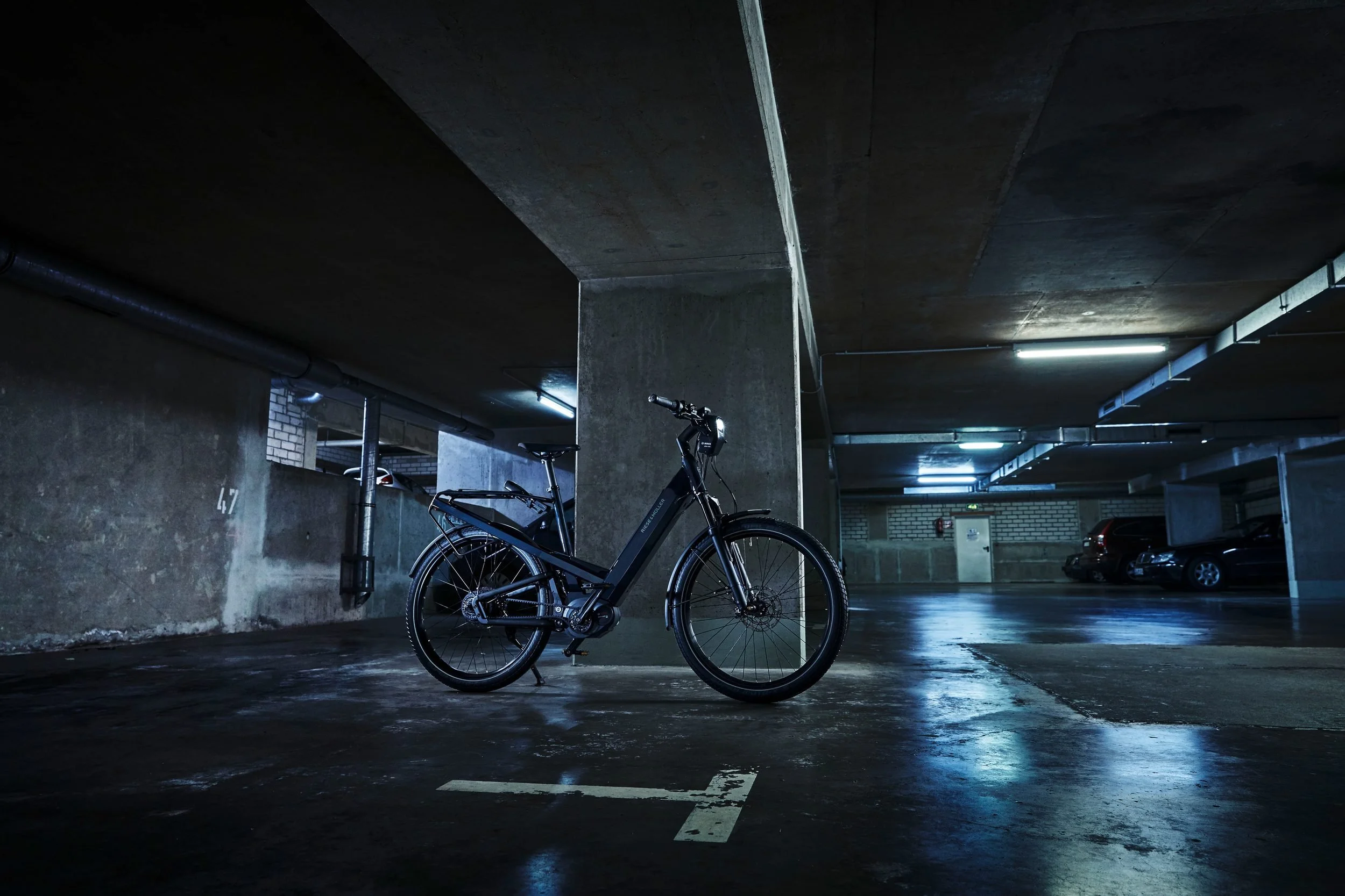 E-Bike steht in blauem Neonlicht der Garage