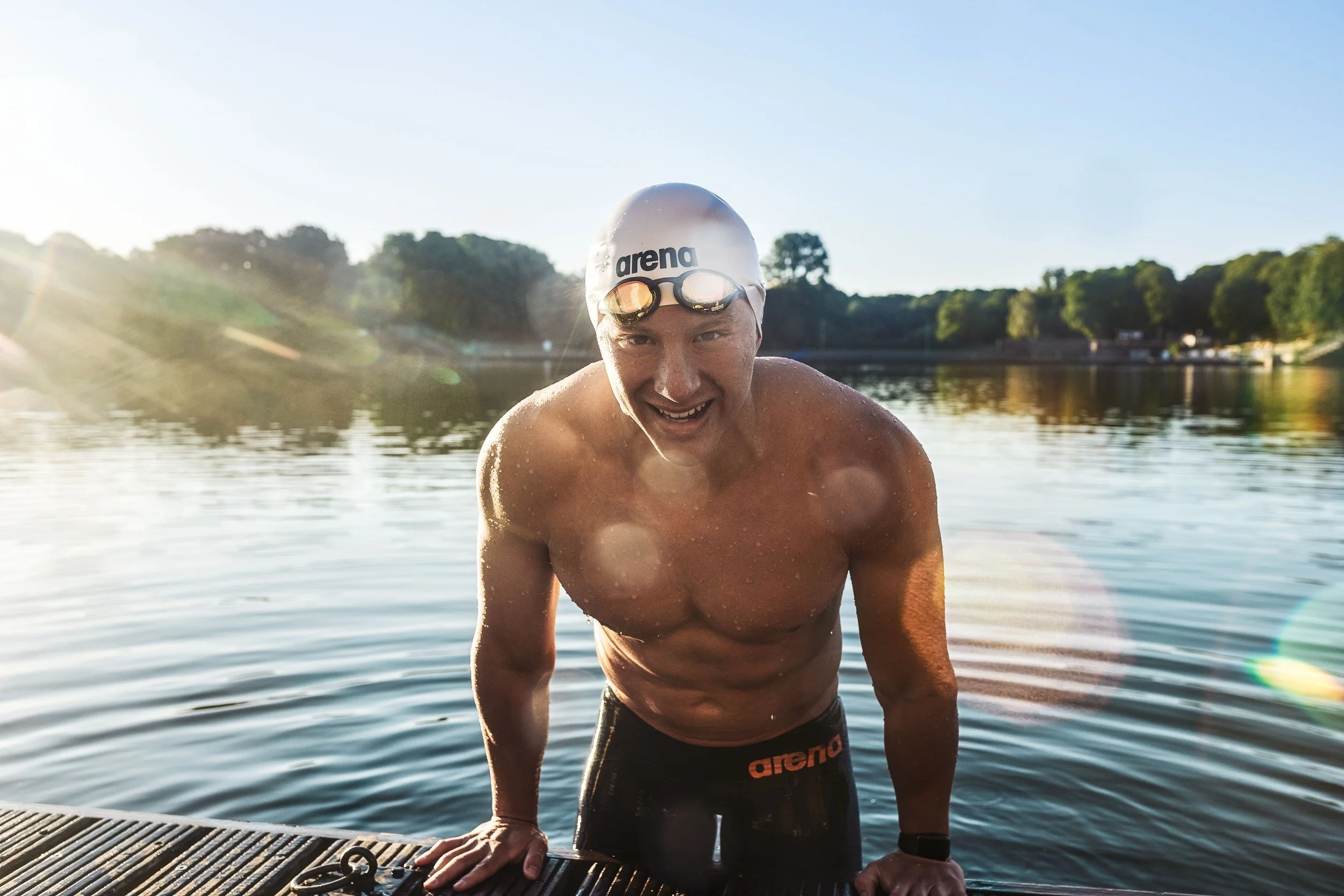 Schwimmer-Editorial von Tim Wendrich: Schwimmer stützt sich im Gegenlicht am Steg auf