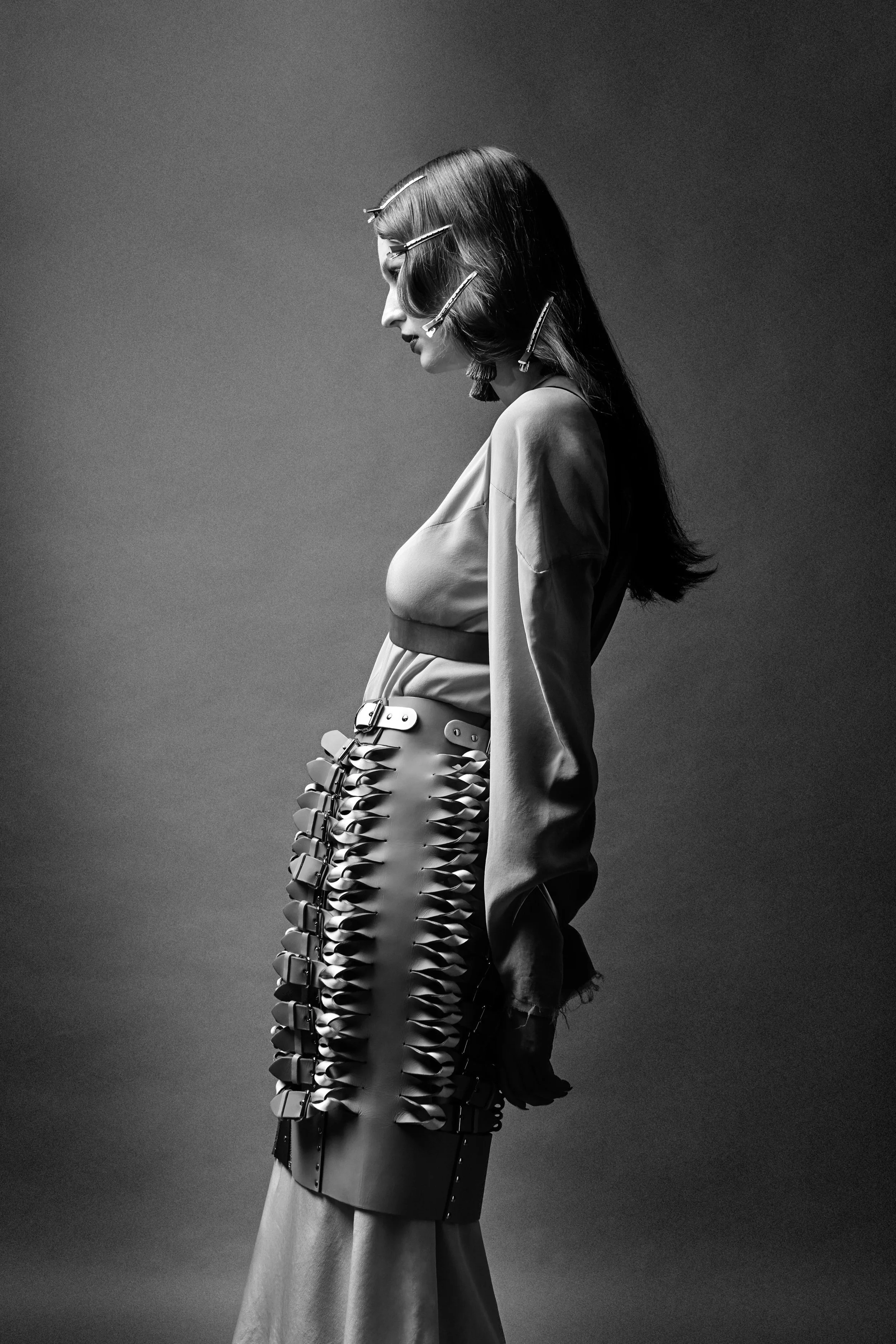 Model im Profil mit Haarclips und Lederrock, elegantes Schwarz-Weiß-Editorial für Knots Magazine – Retusche Bildergut.