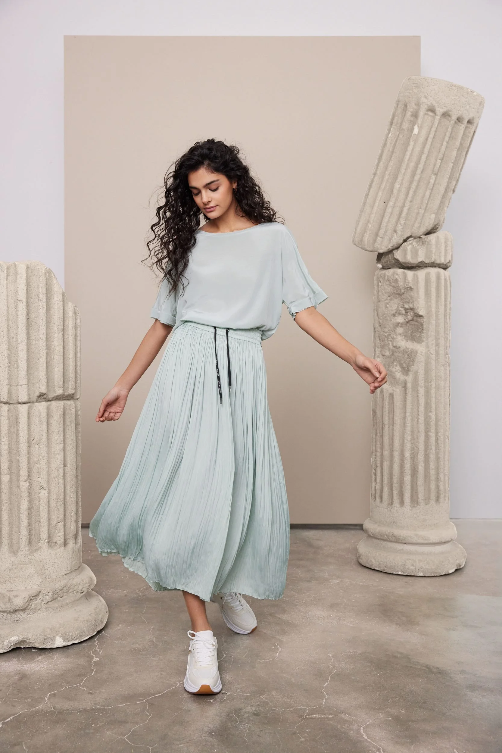 Modehaus Zinser Frühjahr-Sommer 2024: mintgrünes Sommerkleid zwischen antiken Säulen