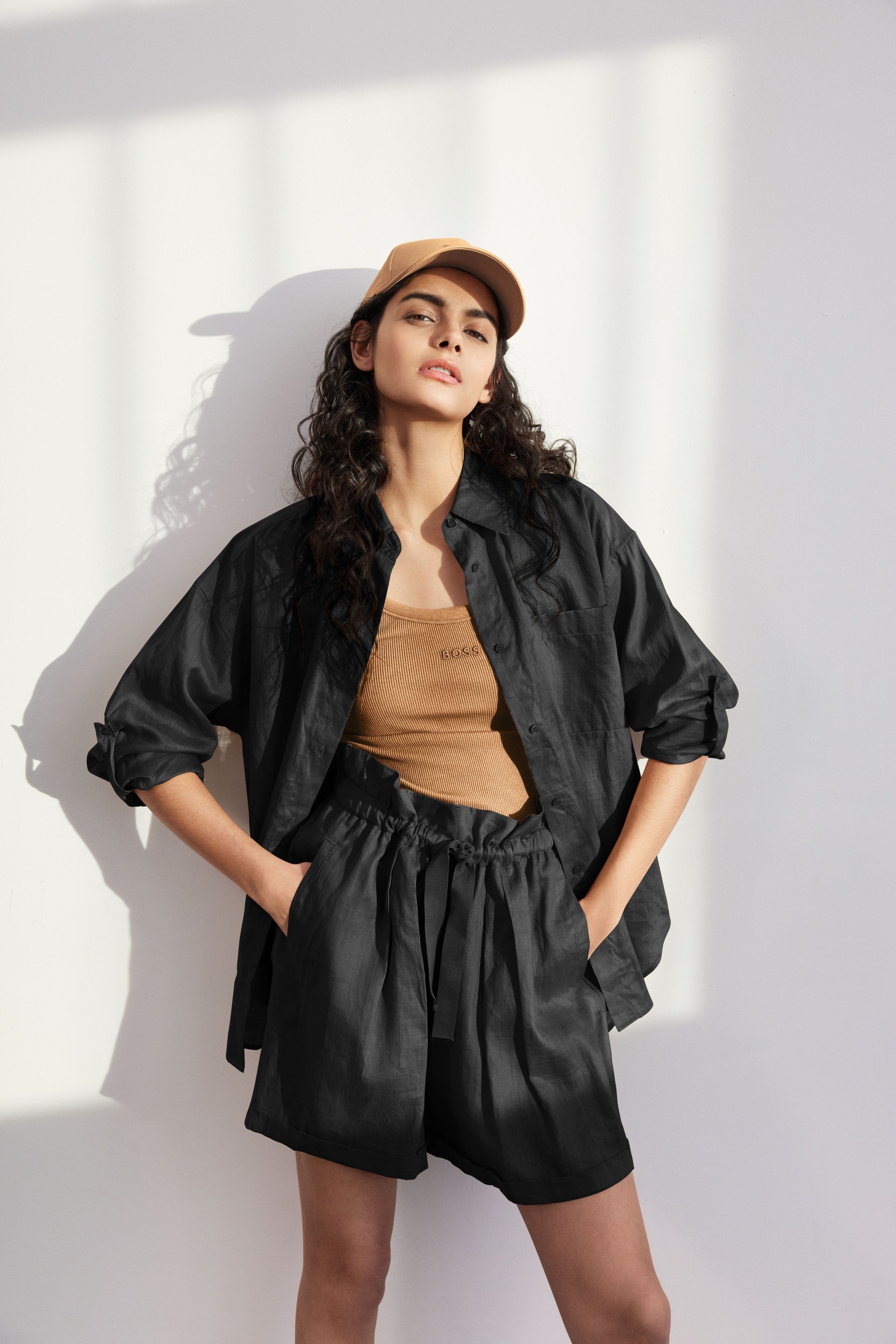 Modehaus Zinser Frühjahr-Sommer 2024: schwarzes Leinen-Set mit Shorts, Basecap und camelfarbenem Top