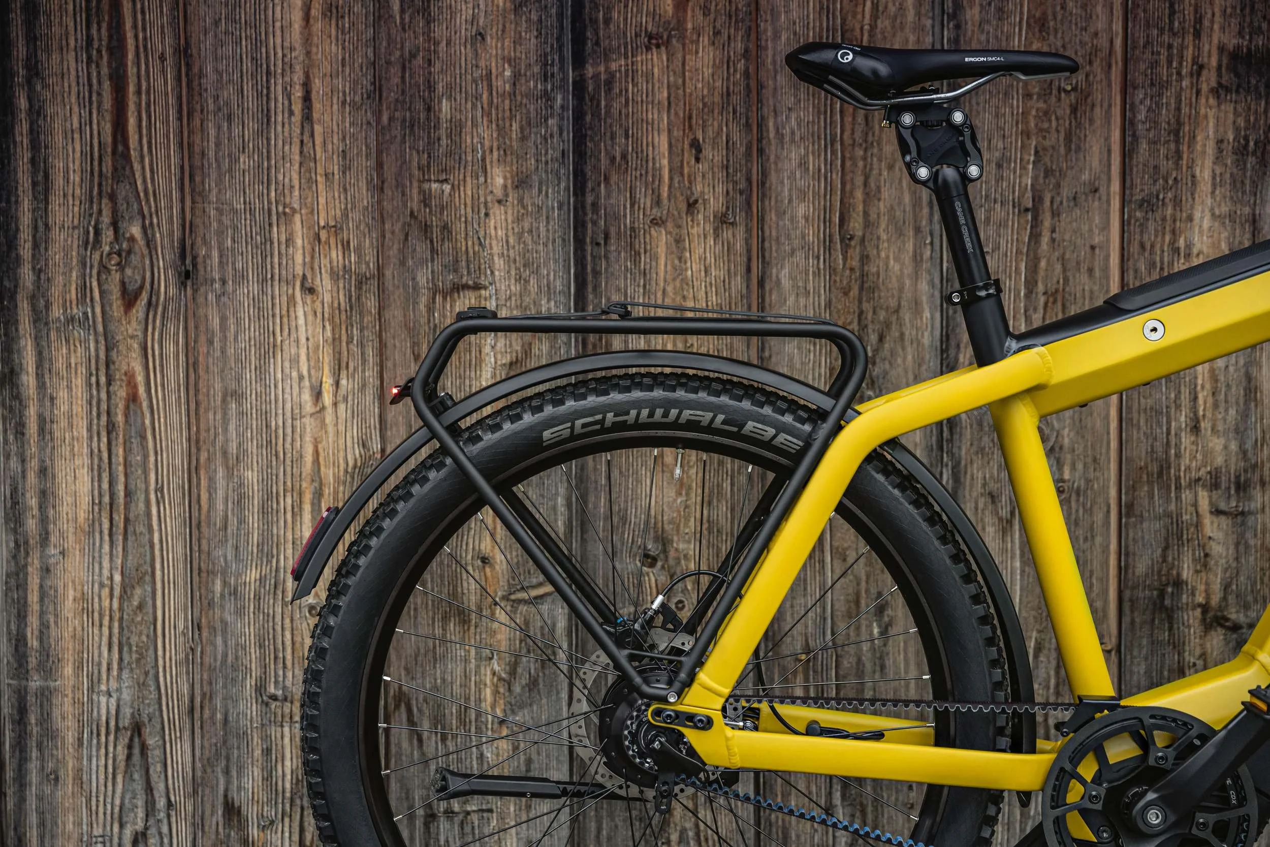 Gelbes Riese & Müller E-Bike vor rustikaler Holzwand