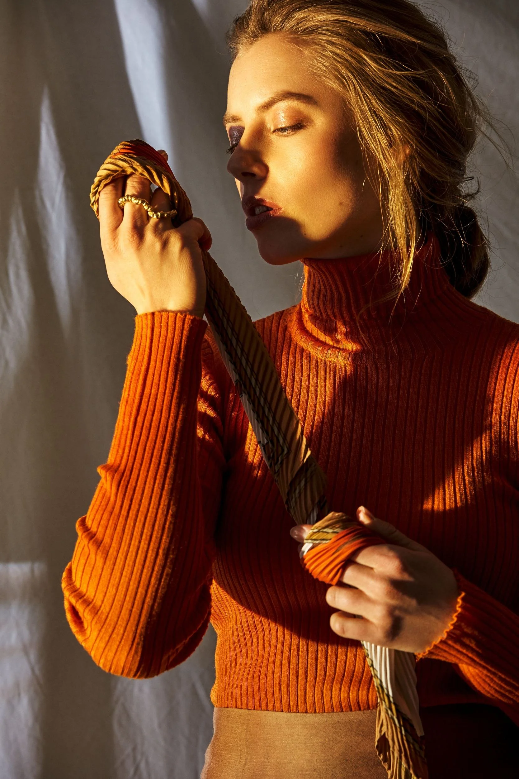 Model mit geflochtenem Zopf und Strickpullover
