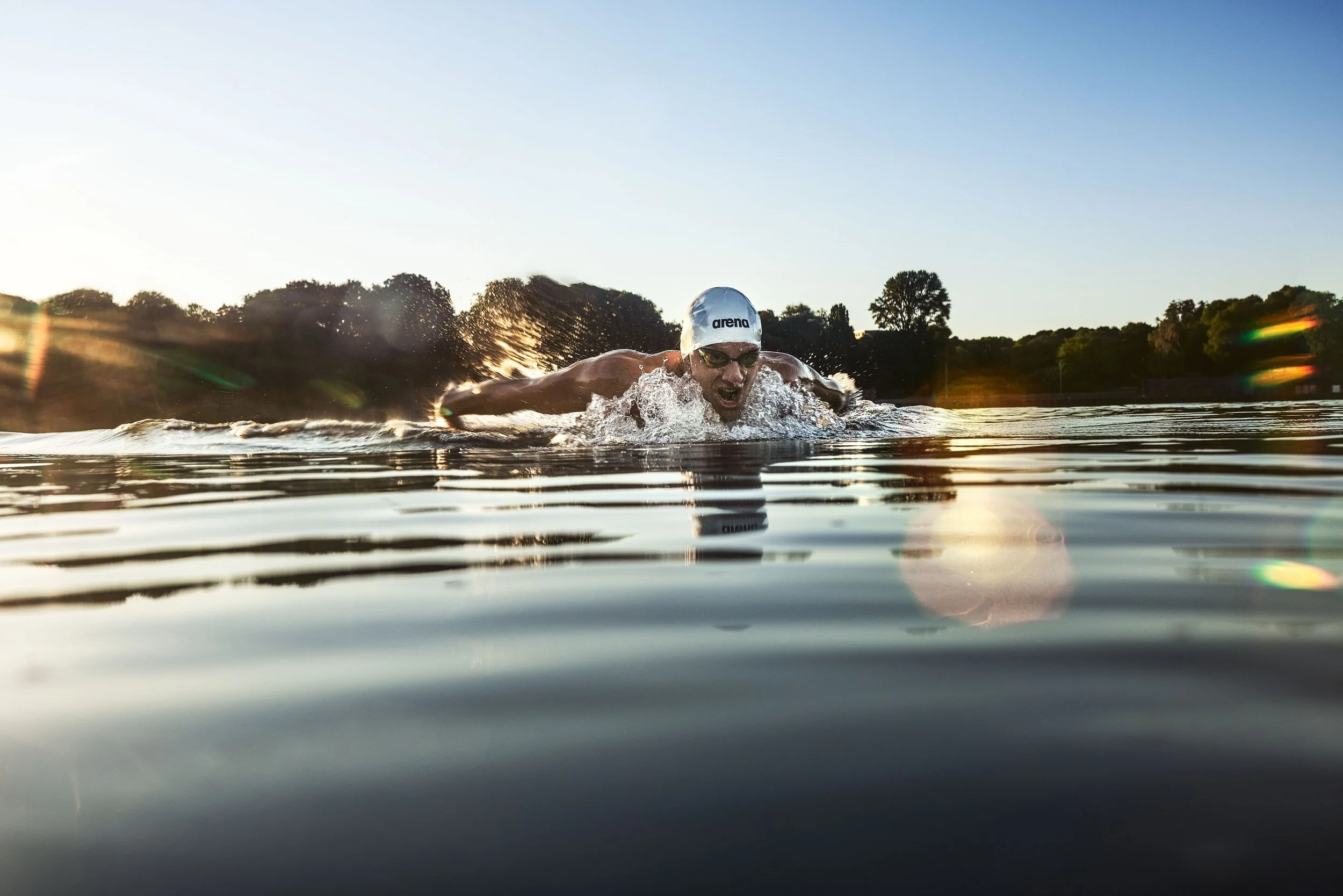 Schwimmer-Editorial von Tim Wendrich: Kraul frontal mit Sonnenreflexen und Streulicht