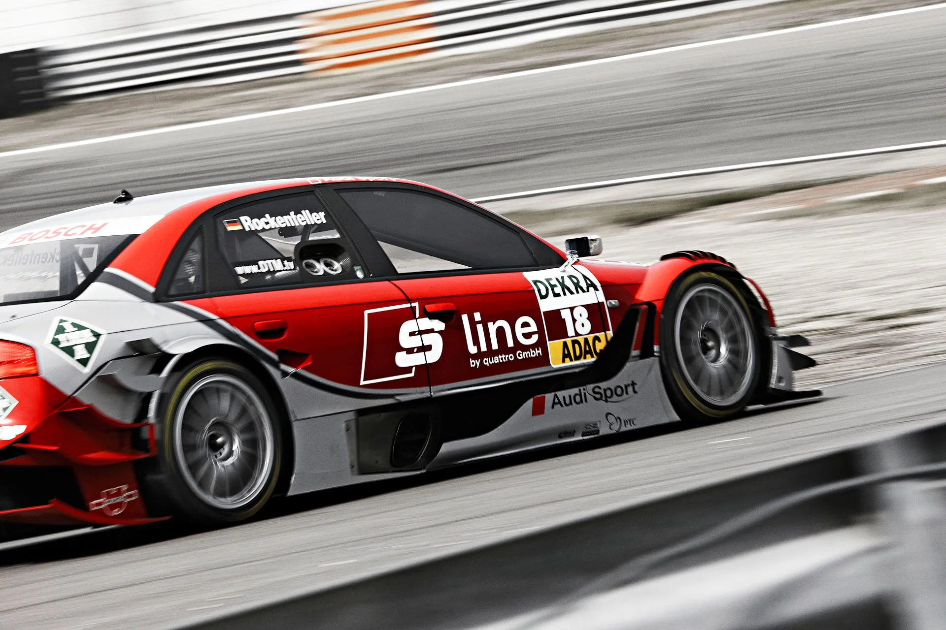 Rot-grauer Audi S line DTM-Rennwagen in schneller Fahrt auf der Rennstrecke – Retusche Bildergut.