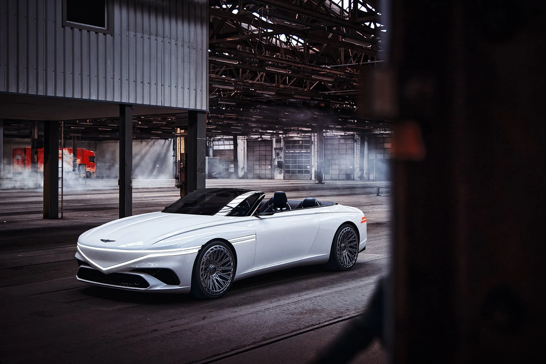 Weißes Genesis X Convertible Concept Car in industrieller Halle mit Nebel – Retusche Bildergut.