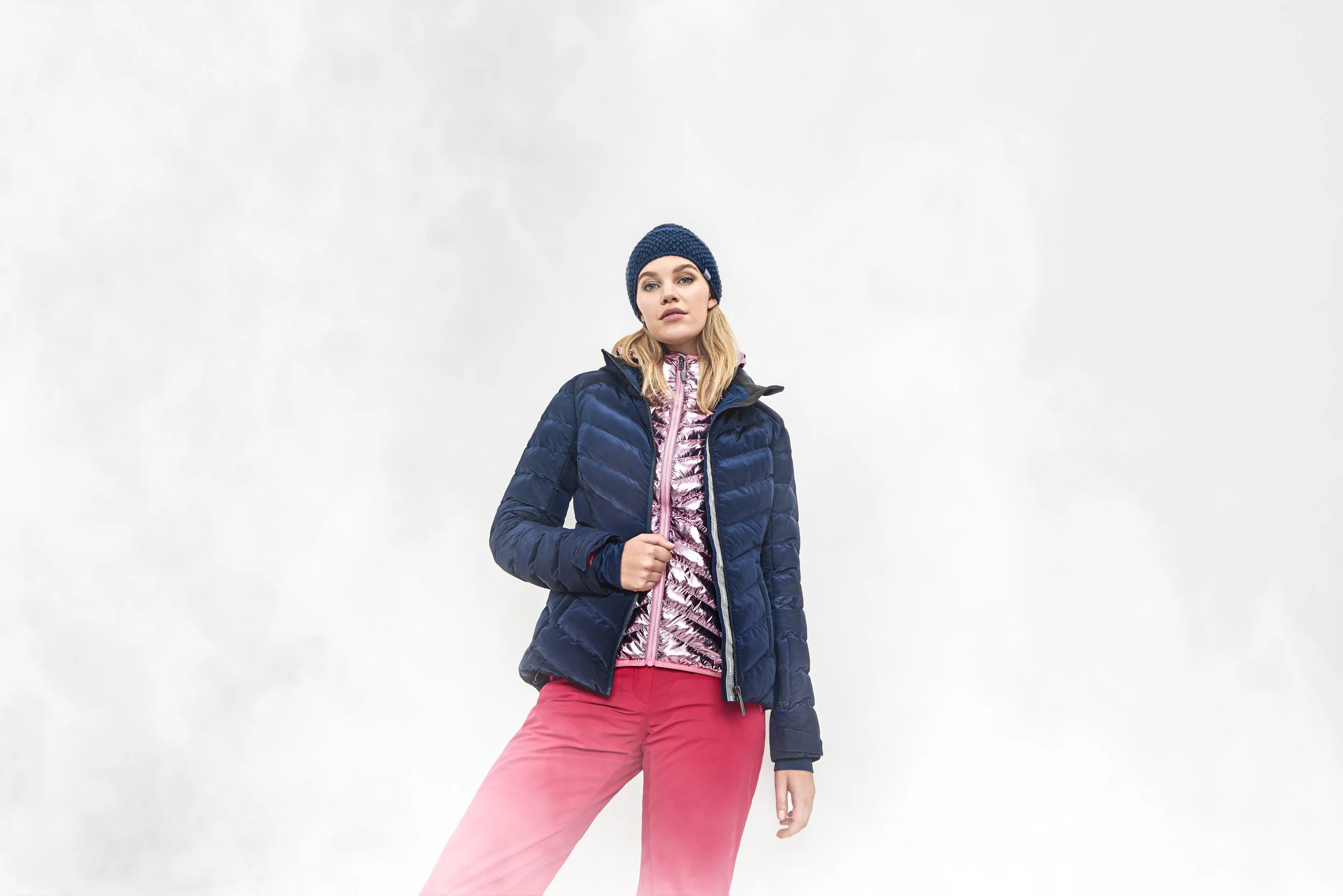 Frau in dunkelblauer Jacke mit roter Hose im Nebel