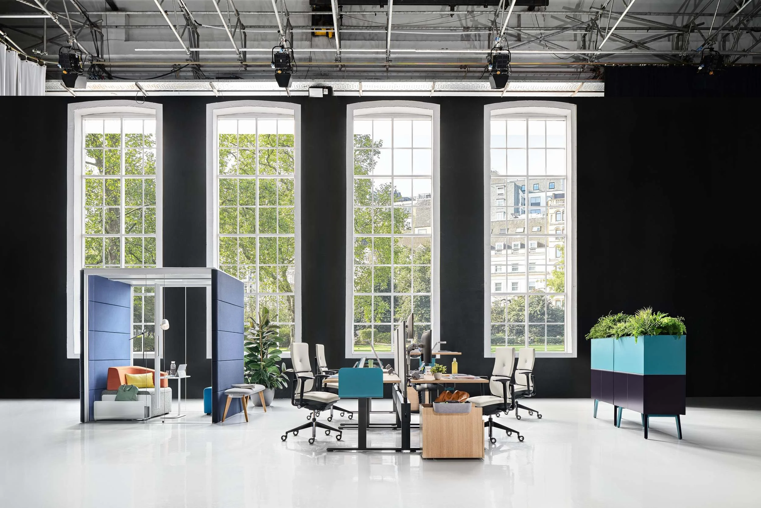 Steelcase Bürolandschaft im Loft mit blauer Akustik-Kabine und Teamarbeitsplätzen
