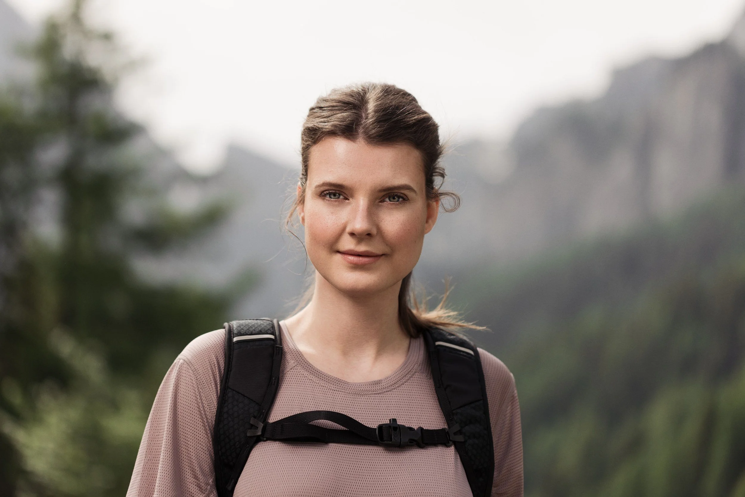 Wanderin mit Rucksack vor Bergwald