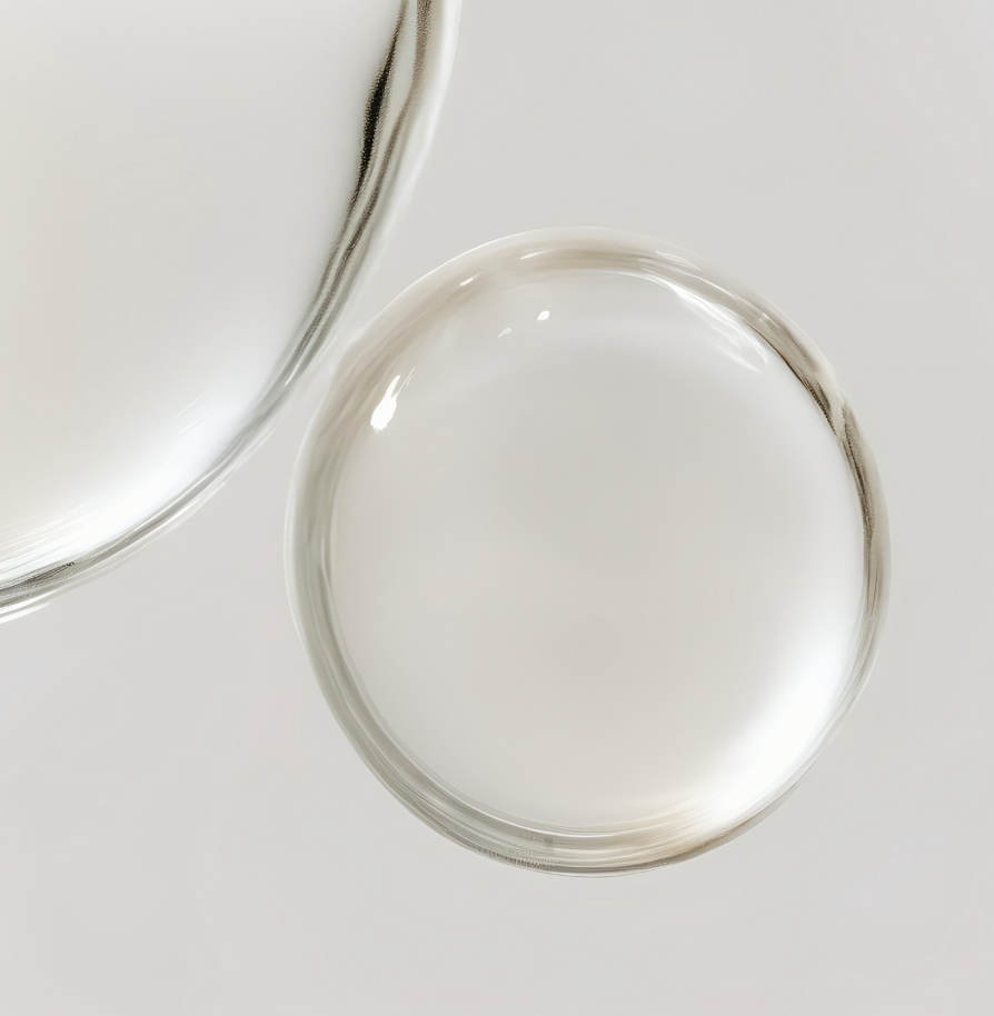 Dos vasos de cristal con líquido transparente, sobre un fondo blanco.
