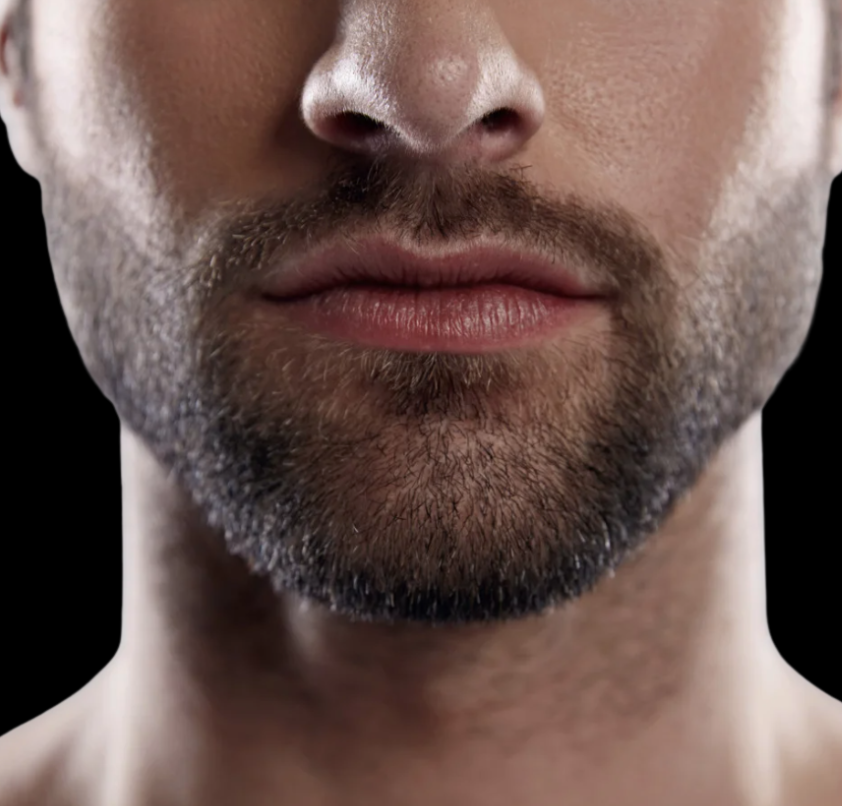 Primer plano de la boca y barba de un hombre con barba bien cuidada y labios cerrados.