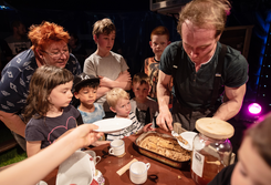 Teacrobat; Akrobat verteilt Kuchen an Kinder