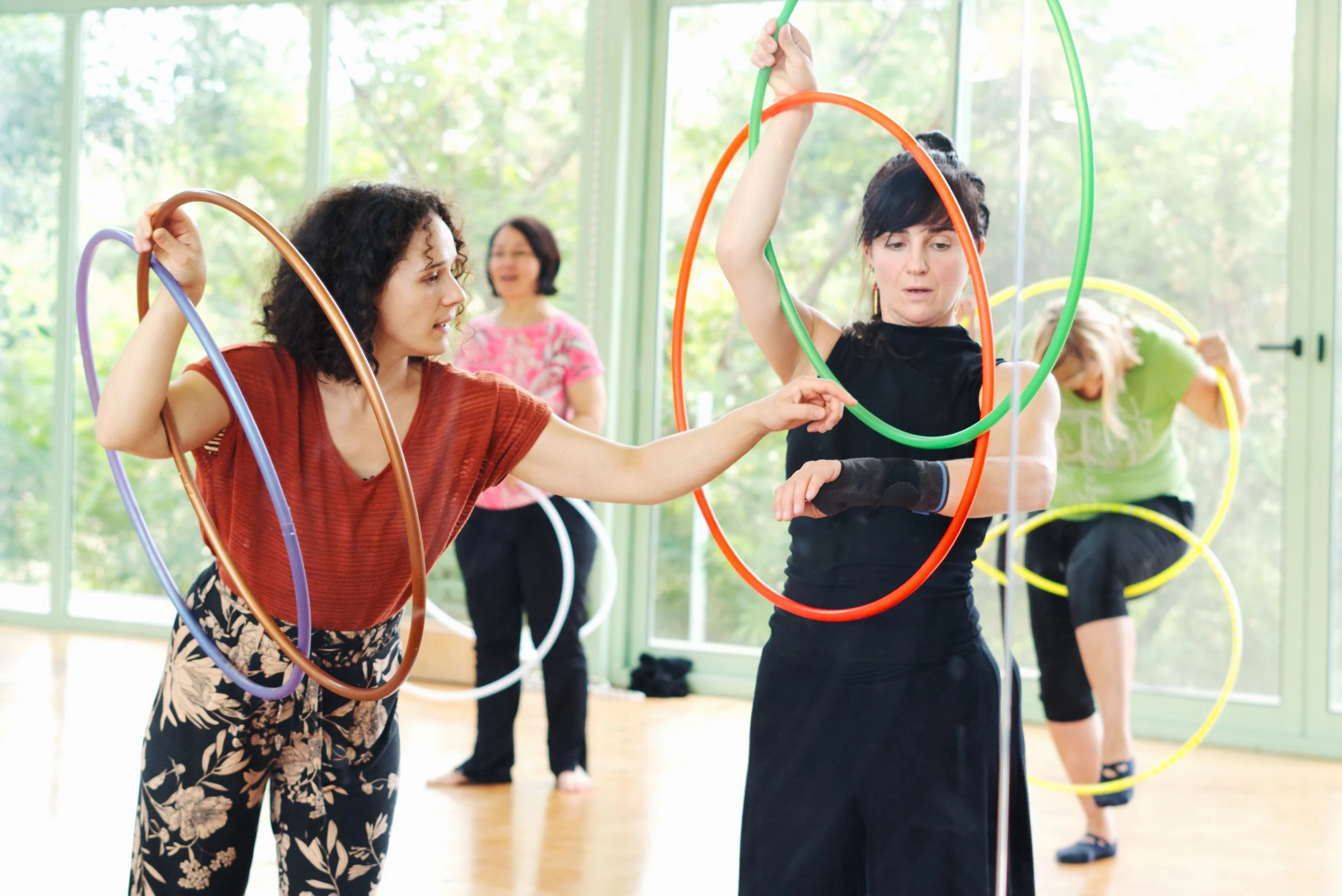 Hoop Dance: zwei Frauen halten bunte Reifen in den Händen