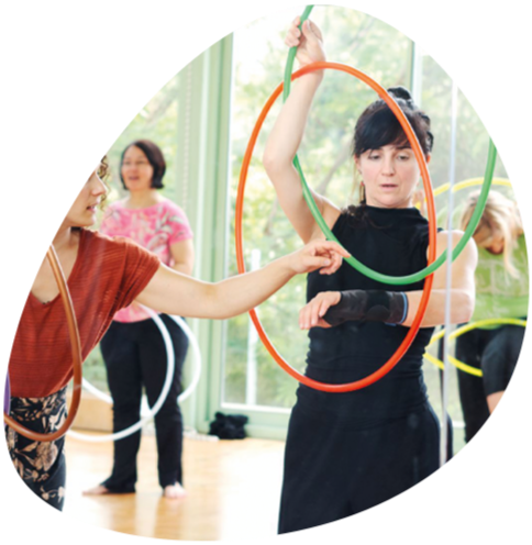 Hula-Hoop Dance Workshop: Frau mit bunten Reifen in Händen