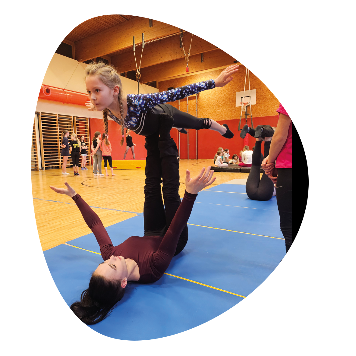 open Circus School, ein Kind wird von einer erwachsenen am Rücken liegenden Person auf den Füßen balanciert