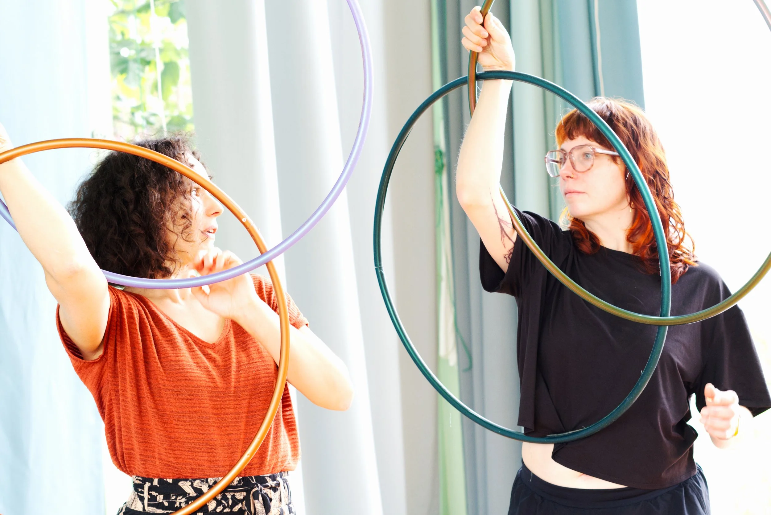 Hoop Dance Workshop: zwei Frauen mit bunten Reifen in der Händen drehend
