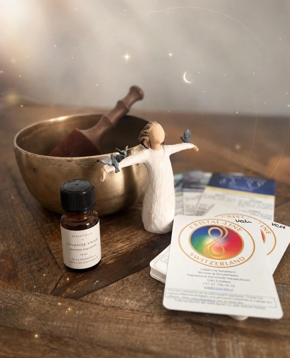 Une table en bois avec une petite figurine de Jésus avec des oiseaux, une boule de cristal, une bouteille d'huile essentielle de lavande, un bol en métal avec un pilon, et des brochures de cristal de Suisse. Des étoiles, la lune et des planètes flottent en arrière-plan.