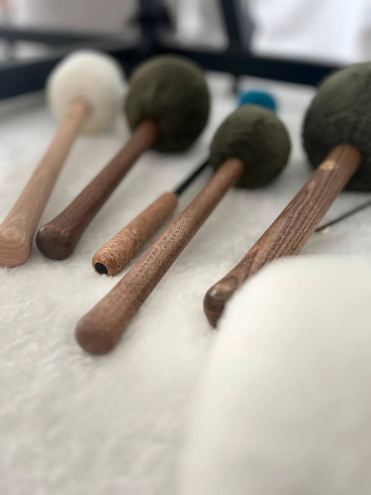 Différents types de marteaux en bois avec des poignées en bois, exposés sur une surface blanche.