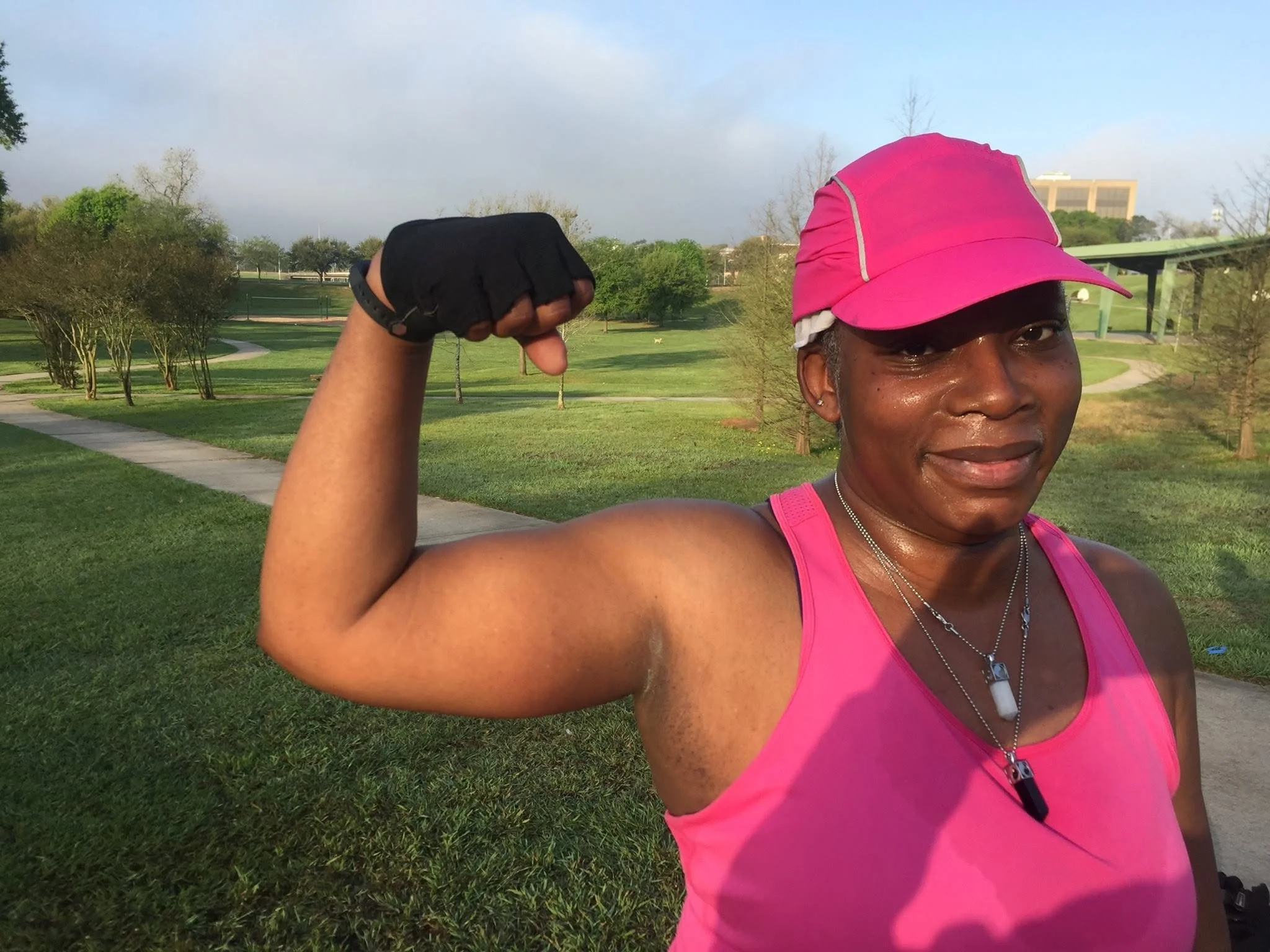 Woman flexing her arm after strength training with Body By U Fit in Central Houston, TX