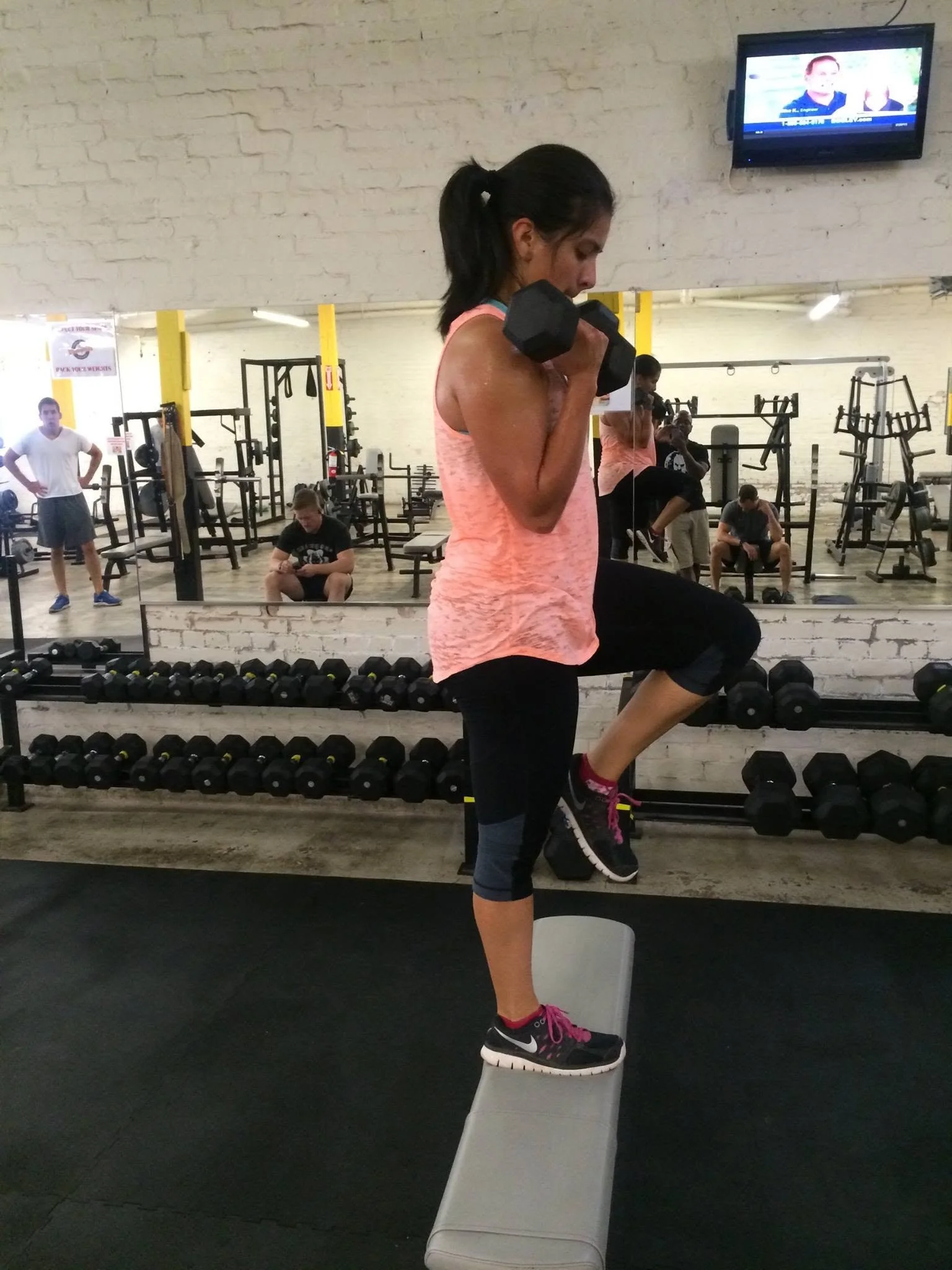 Woman performing step-ups during strength training with Body By U Fit in Houston