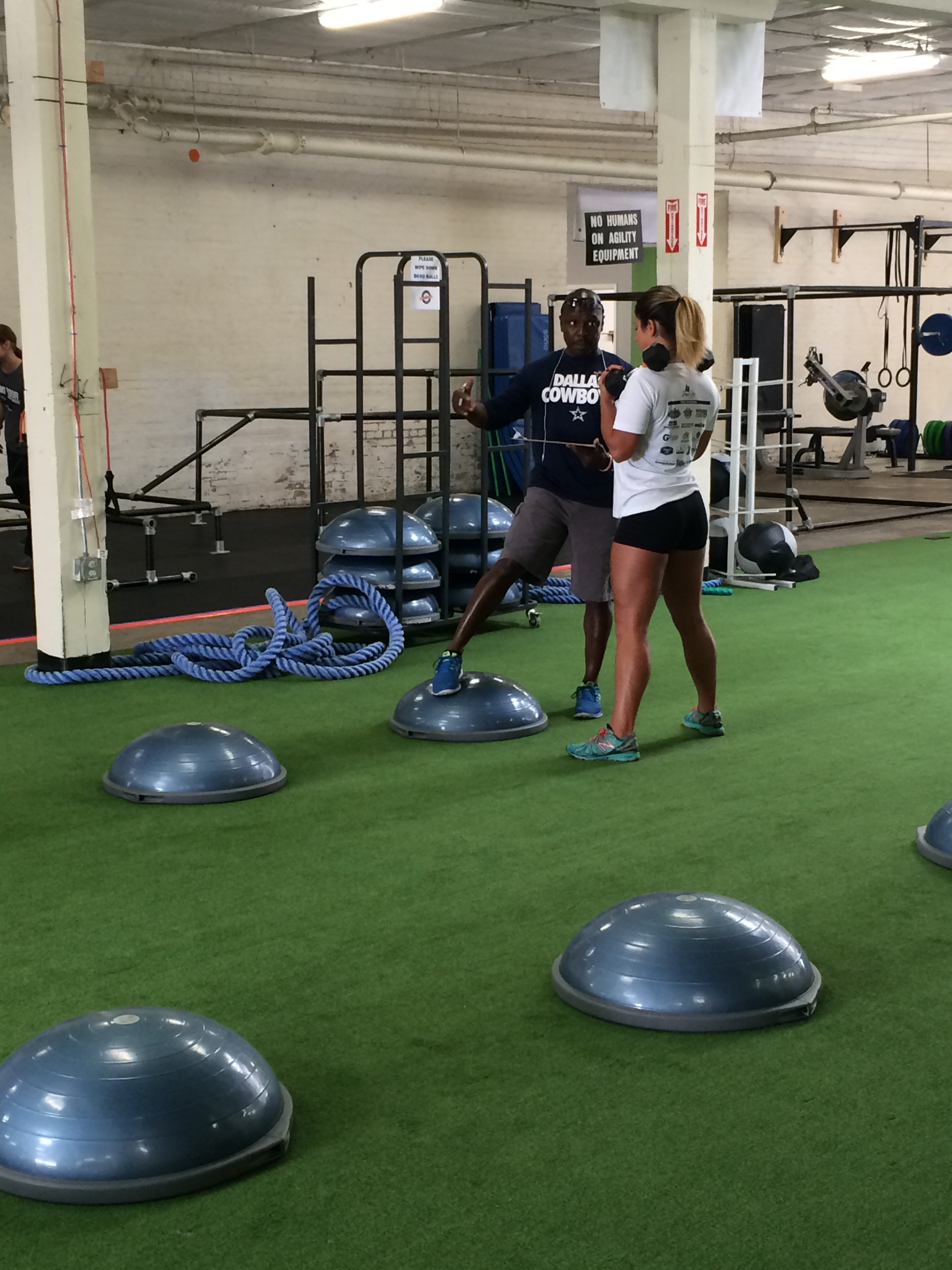 Coach Phil performing a one-on-one fitness assessment with a new client at Body By U Fit in Central Houston before starting a personalized women's strength training program.