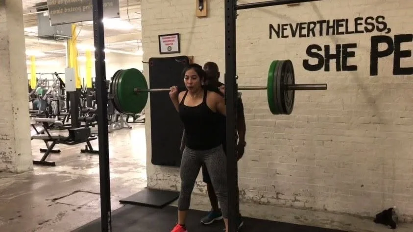 Woman performing a barbell strength training exercise under Coach Phil's guidance at Body By U Fit in Central Houston, building strength with proper technique and progressive coaching.