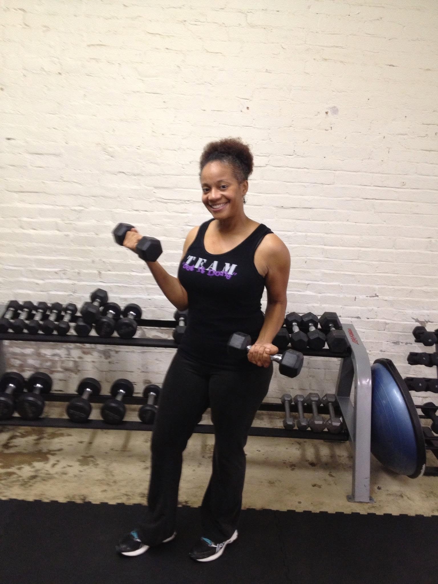 Tomeka performing a dumbbell strength training exercise during a coached workout at Body By U Fit in Central Houston, building strength, confidence, and healthy habits.