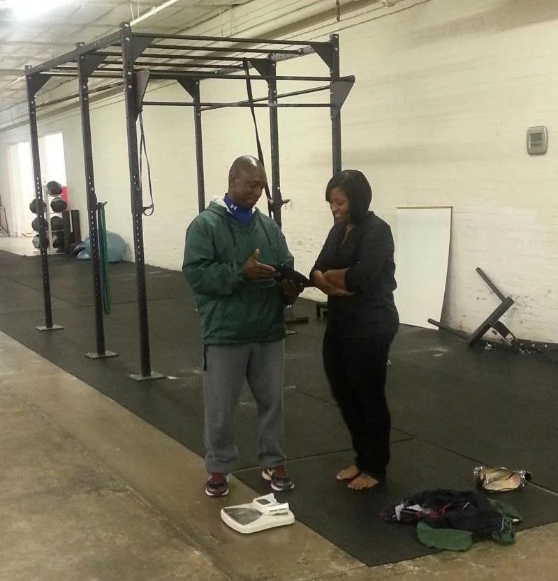 Coach Phil reviewing a fitness assessment with Shelli M during a private strength coaching at Body BY U Fit in Houston.