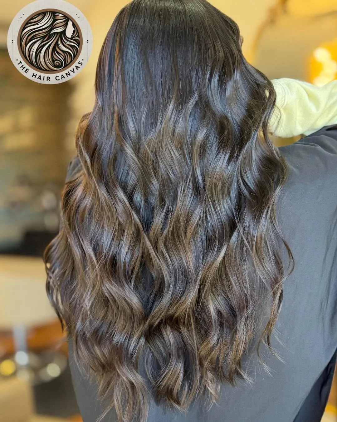 Long, wavy, caramel-colored hair with darker roots, viewed from the back.