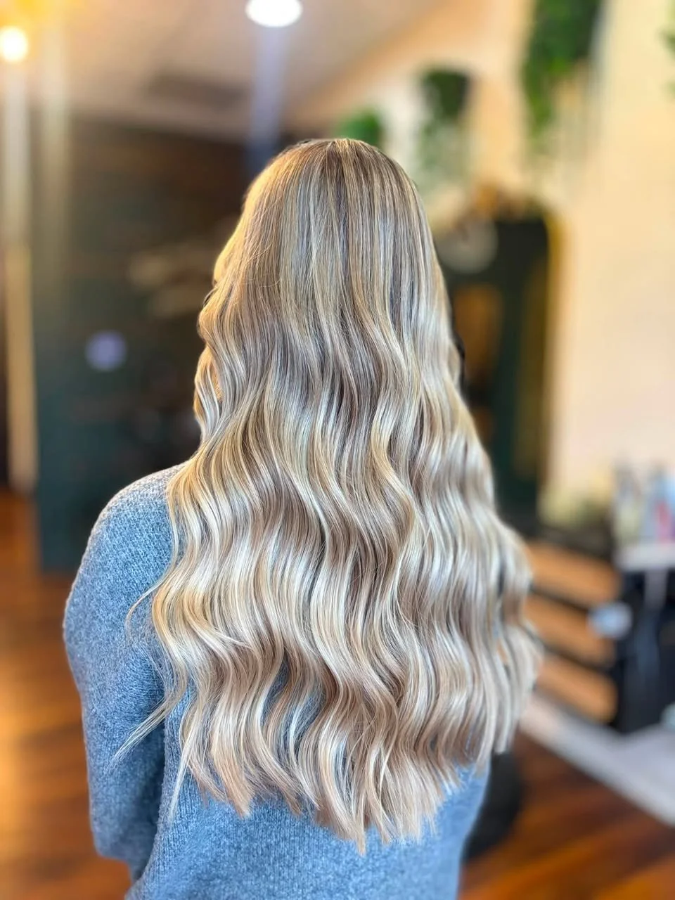 Long, wavy blonde hair featuring dimensional blonding and blended highlights at The Hair Canvas
