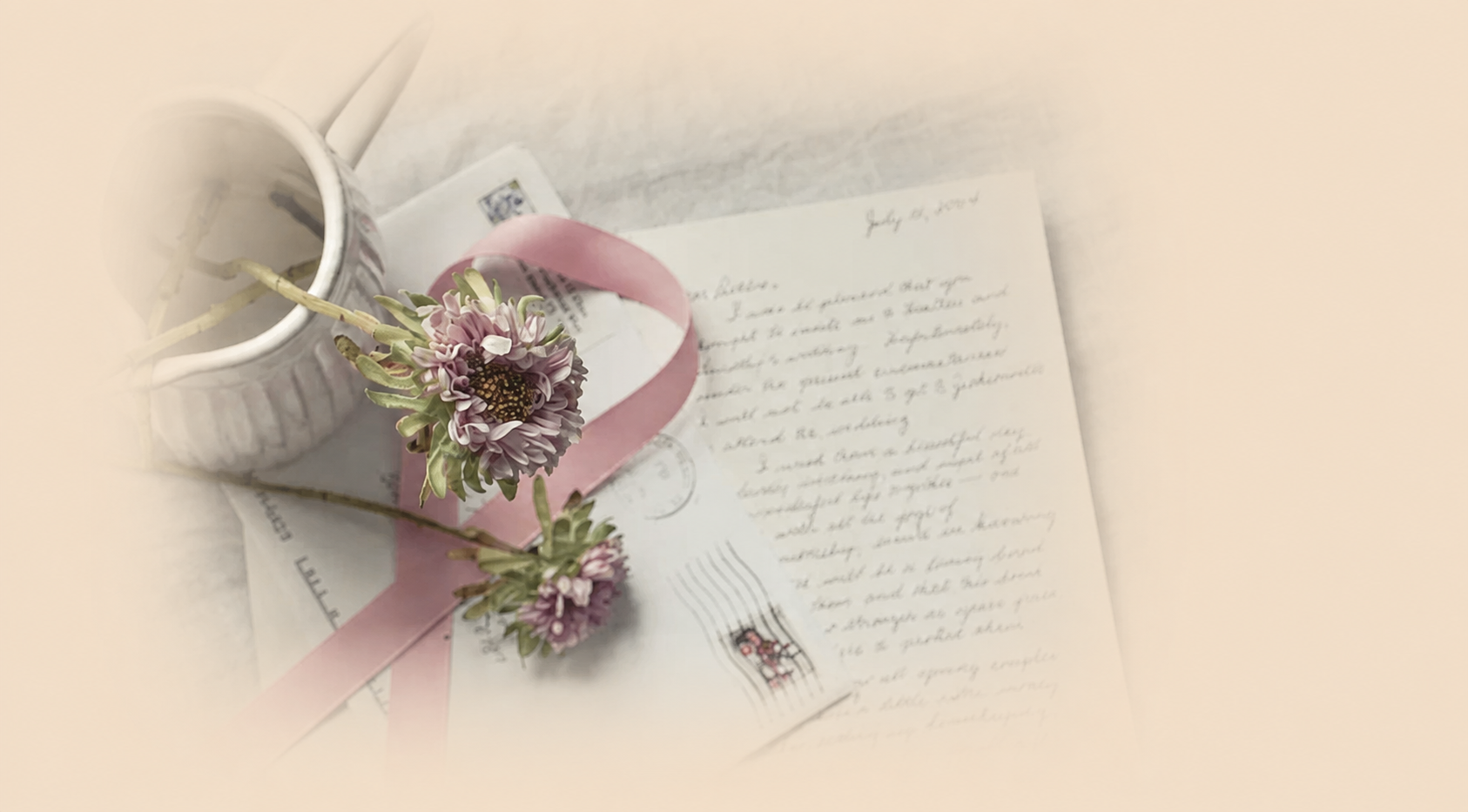 Handwritten letters with small flowers and a pink ribbon in soft daylight.