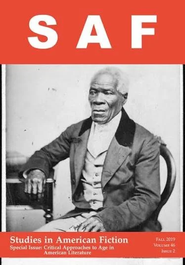 Black and white photograph of an elderly man with white hair, wearing a suit jacket and waistcoat, seated on a wooden chair against a plain wall, with a red banner at the top displaying the acronym 'SAF' in white letters. The bottom has a red band with white text that reads 'Studies in American Fiction, Special Issue: Critical Approaches to Age in American Literature, Fall 2019, Volume 46, Issue 2.'