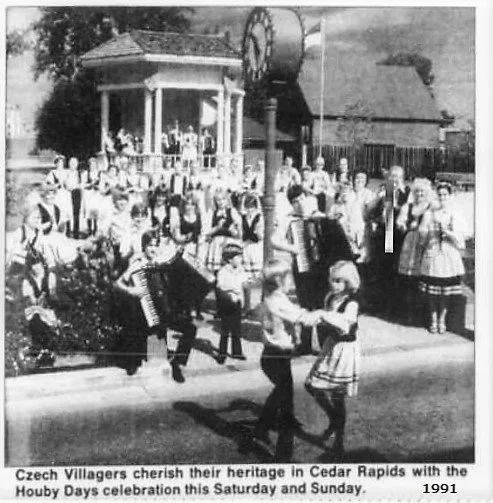 Black and white photo of Czech villagers celebrating Houby Days in Cedar Rapids, with children dancing and villagers in traditional clothing