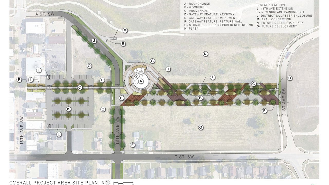 Site plan showing streets, green spaces, and various buildings, including a roundabout, parking lot, and designated areas for future development.