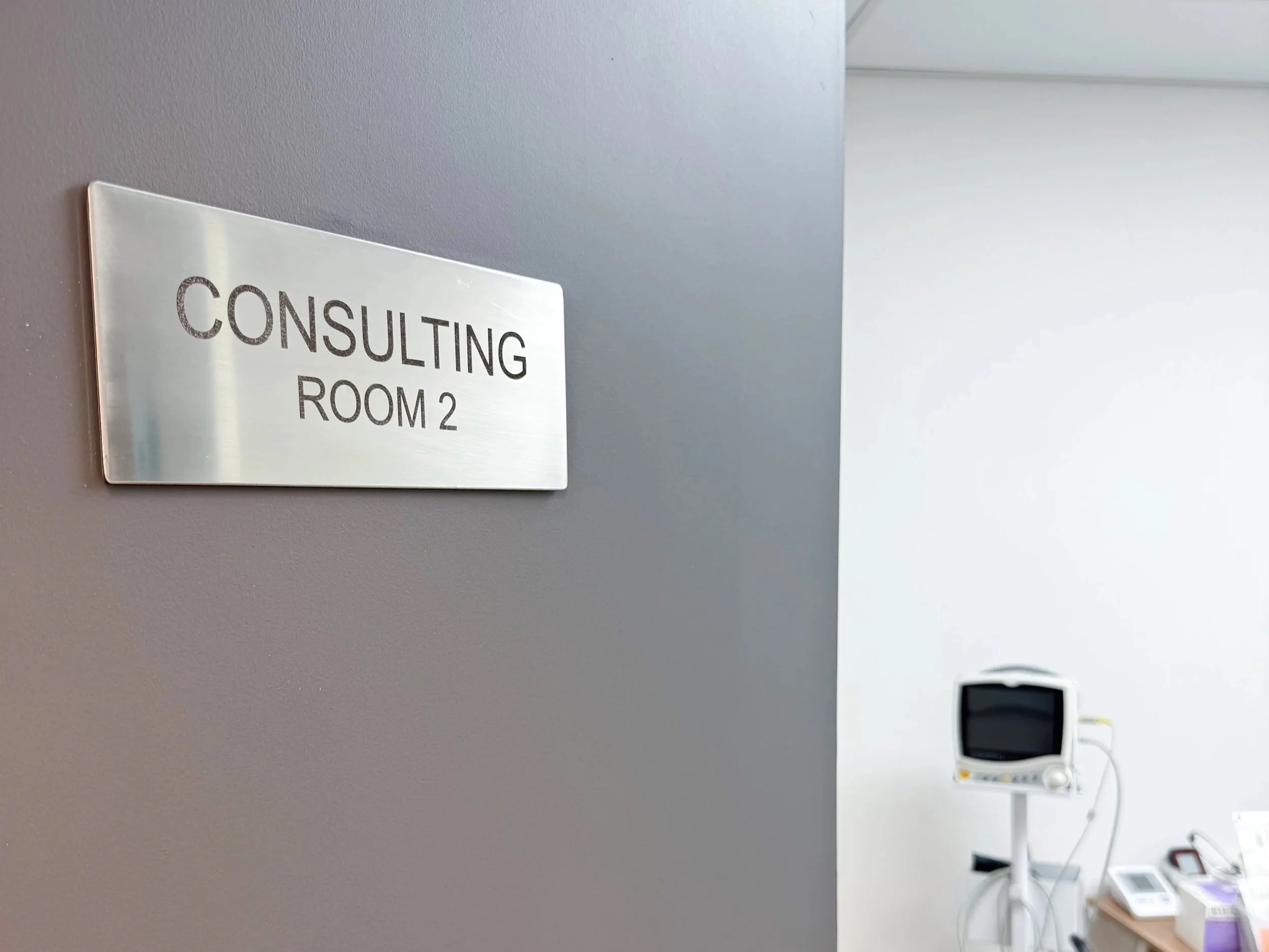 A sign on the clinic door in ABC PHARMACY "Consulting Room 2" showing the place where you can visit the clinic.