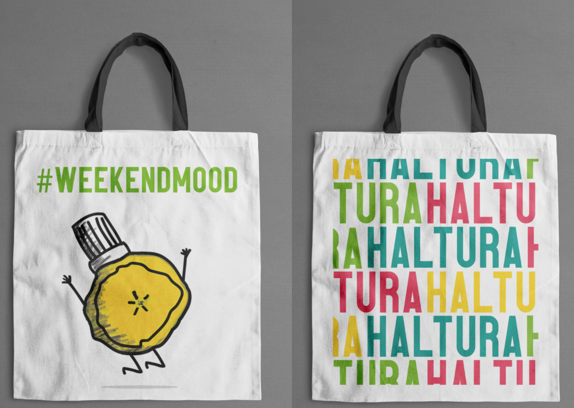 Two white tote bags hanging on a gray background. The left tote bag has the hashtag "#WEEKENDMOOD" in green and a cartoon lemon with arms, legs, and a bottle cap on its head. The right tote bag has a colorful, repeating pattern of the phrase "TUR HAL" in green, pink, yellow, and blue, written in different orientations.
