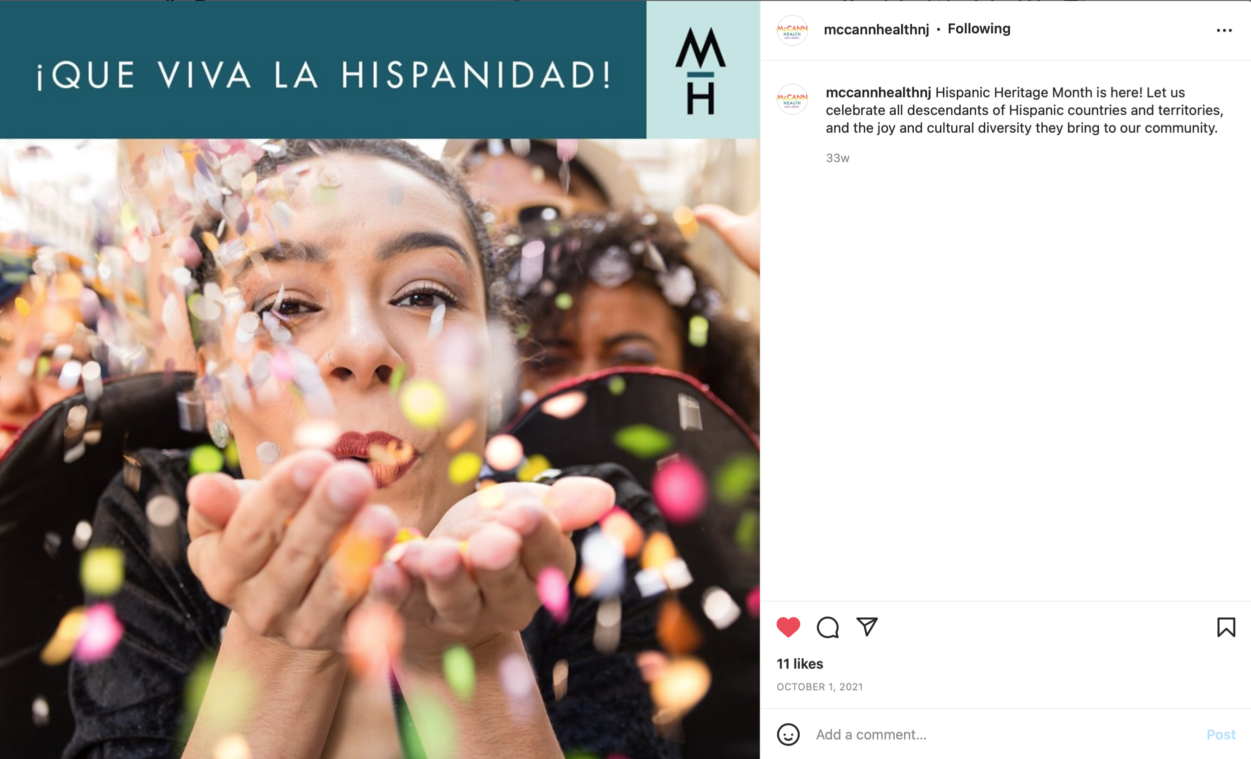 Close-up of a woman with curly dark hair, holding her hands in front of her, with multicolored confetti falling around her during Hispanic Heritage Month celebration.