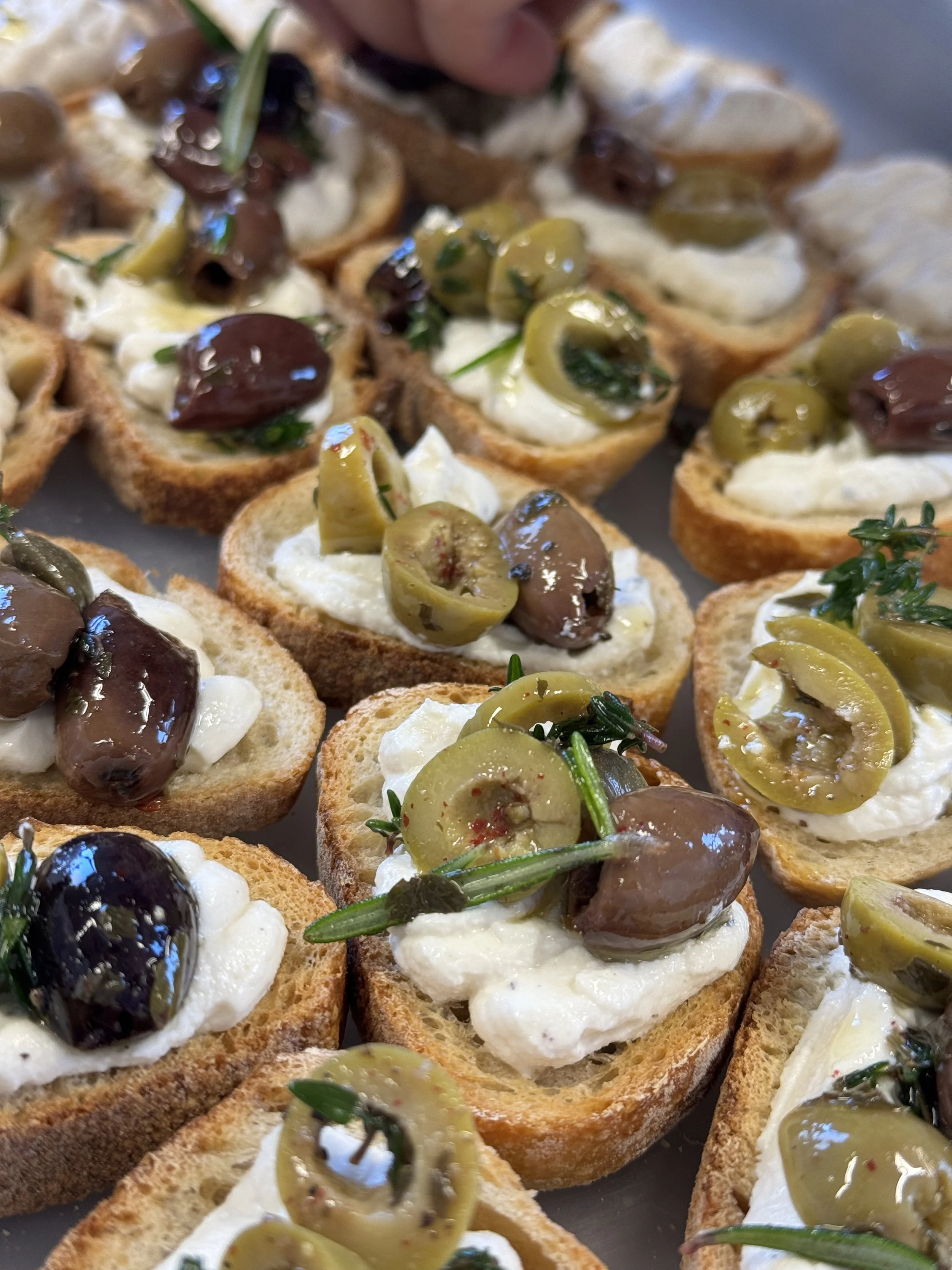 Croûtons avec fromage, olives vertes, olives noires et herbes.
