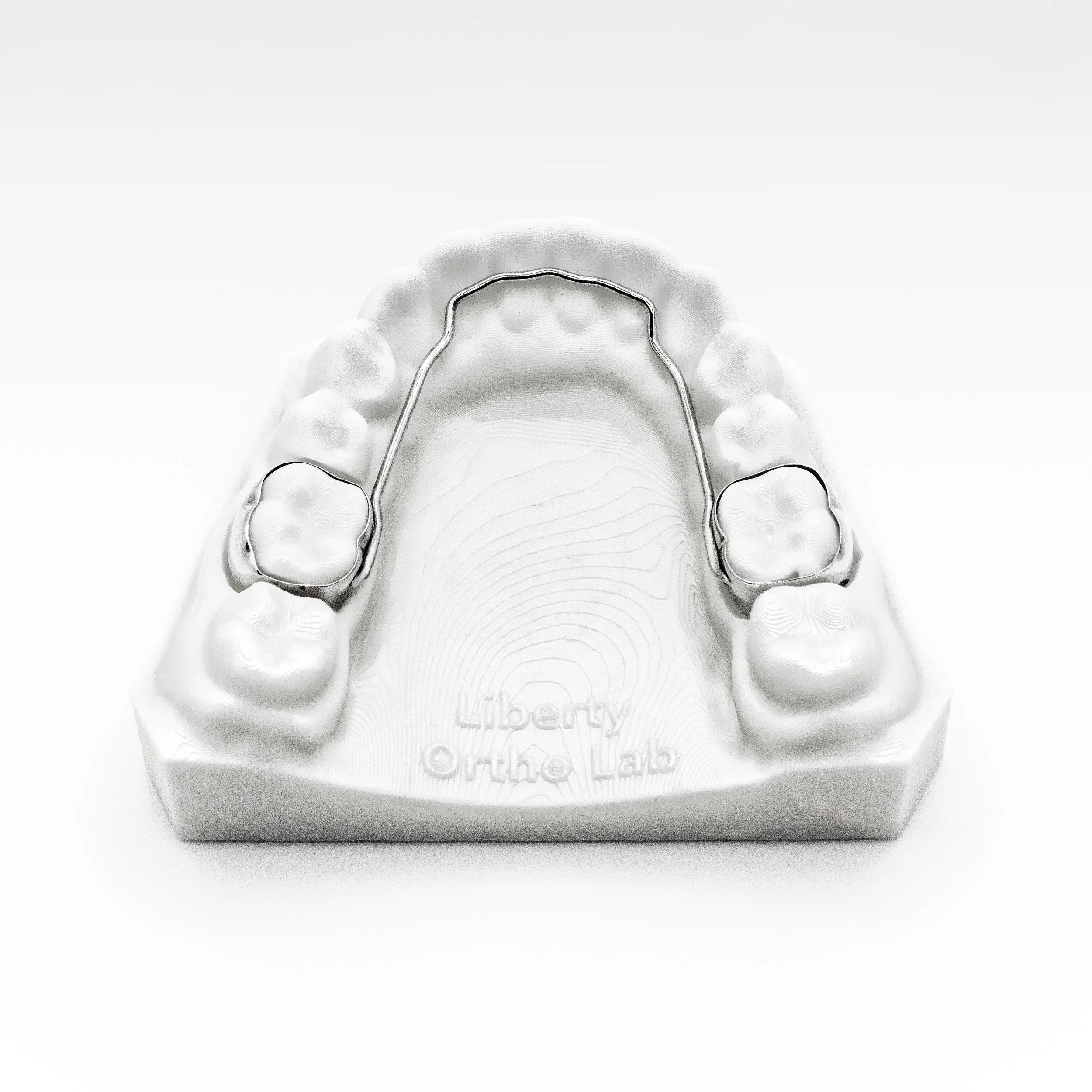 A dental impression tray with a dental impression material, placed inside a white box with the logo and text 'Liberty Oral Care' embossed on it.