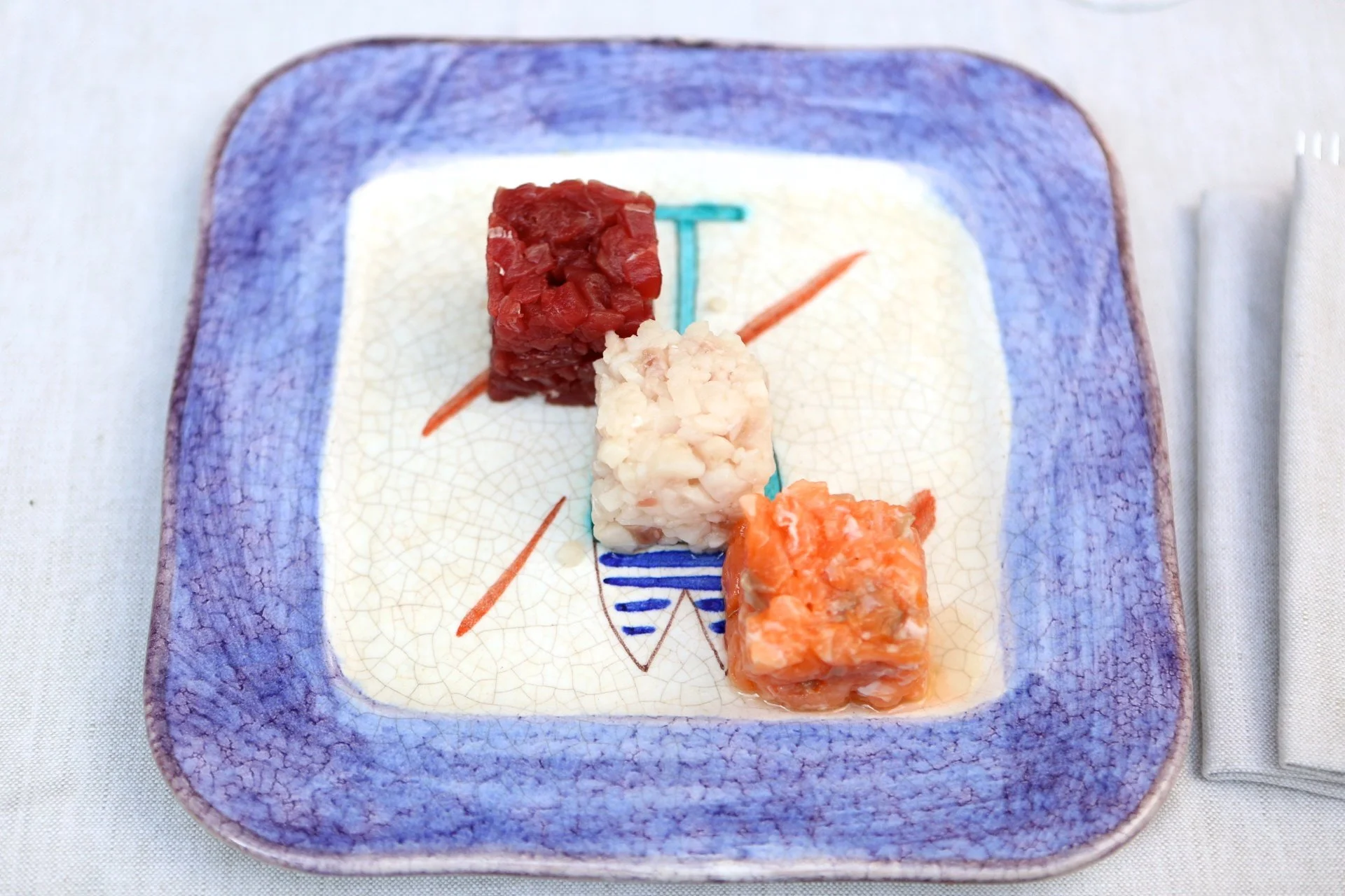 Tris di tartare: tonno, ricciola e salmone sul piatto di Pesciolini