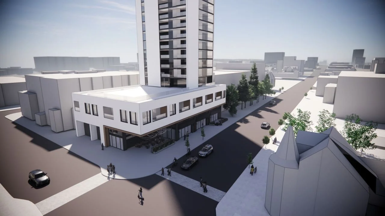 A cityscape rendering showing a tall modern building with a retail space on the ground floor, surrounded by trees, sidewalks, and pedestrians. Several cars are parked along the street.