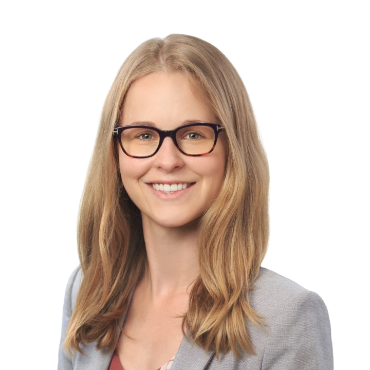 A woman with long blonde hair, glasses, and a gray blazer smiling at the camera.