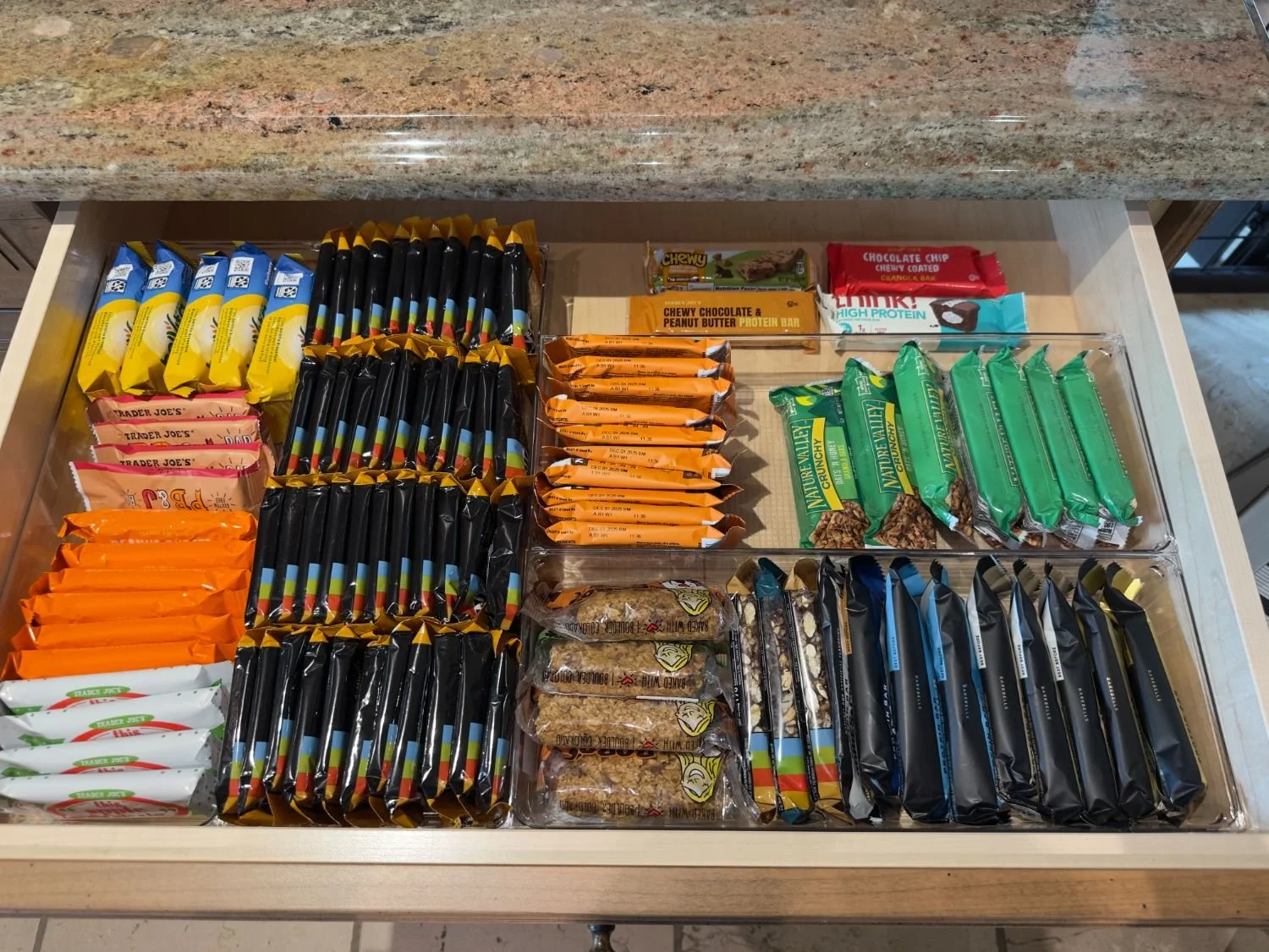 Drawer organizer with pens, markers, pencils, and office supplies sorted by category. 