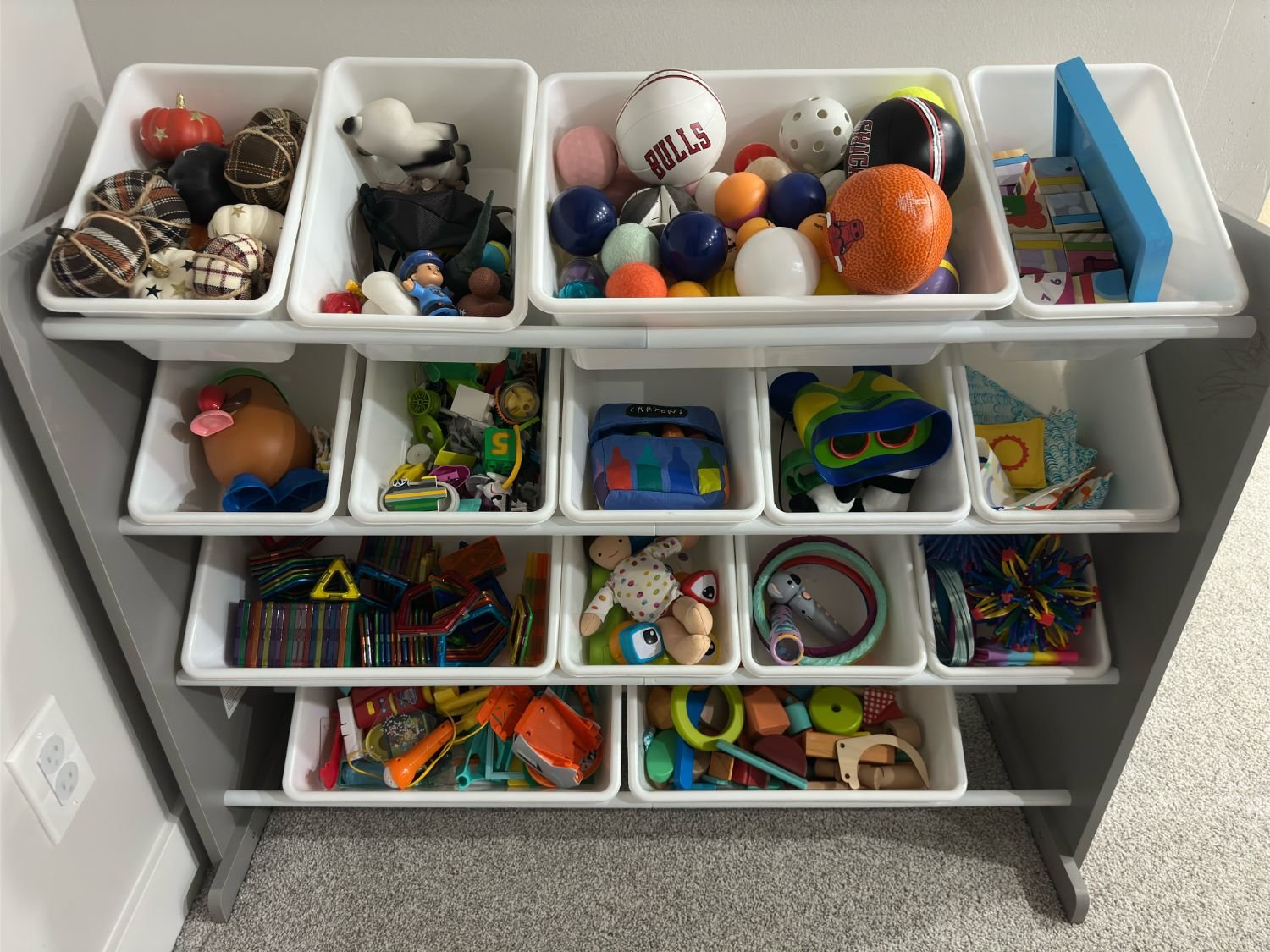 Kids' playroom organization featuring categorized toy bins and open shelving. 
