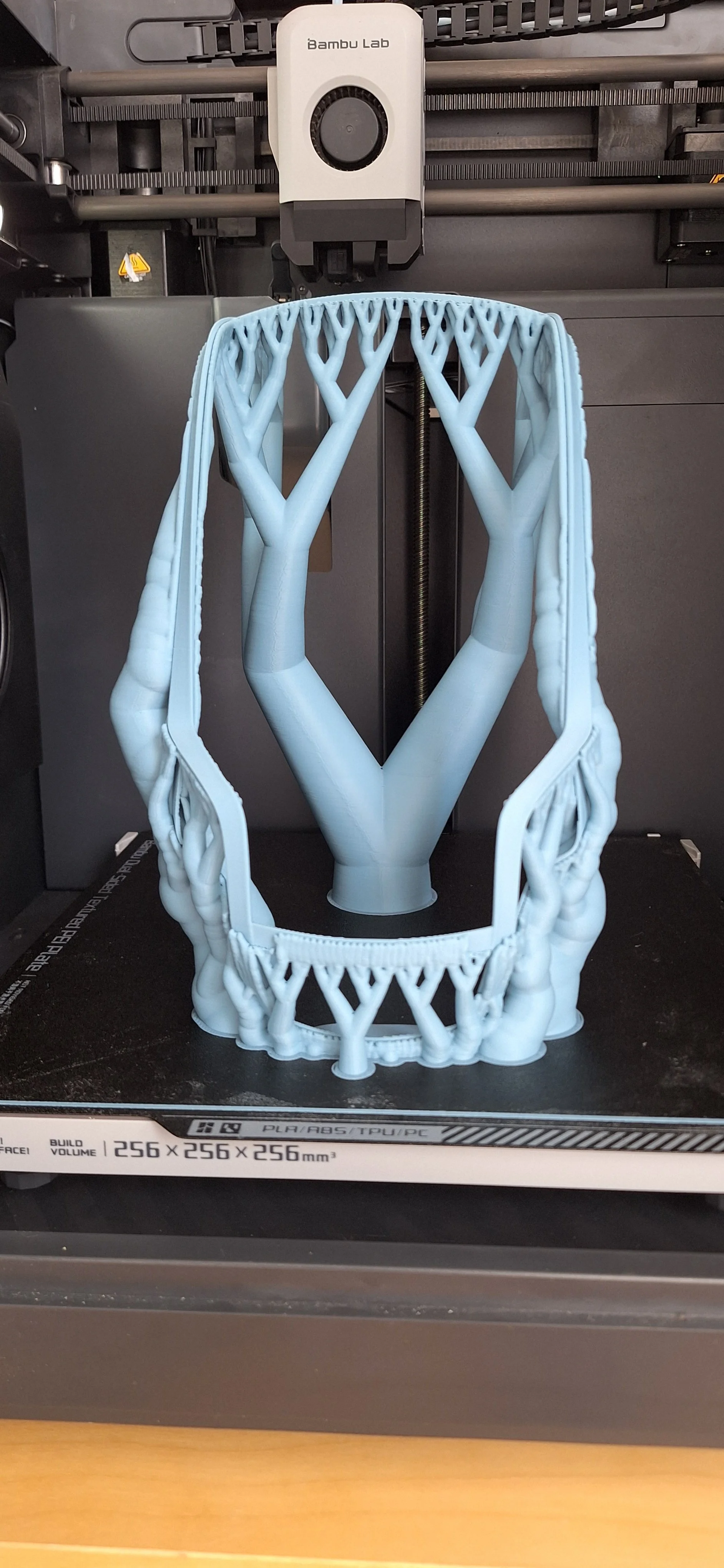 Modèle 3D imprimé représentant un arbre stylisé avec plusieurs branches et un tronc, situé sur une imprimante 3D.